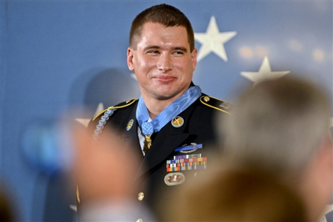 Former Army Sgt. Kyle J. White smiles as the audience applauds after President Barack Obama awarded him the Medal of Honor for conspicuous gallantry during a ceremony at the White House, May 13, 2014. White received the medal for courageous actions while serving as a platoon radio telephone operator during combat operations against an armed enemy in Afghanistan's Nuristan province, Nov. 9, 2007.