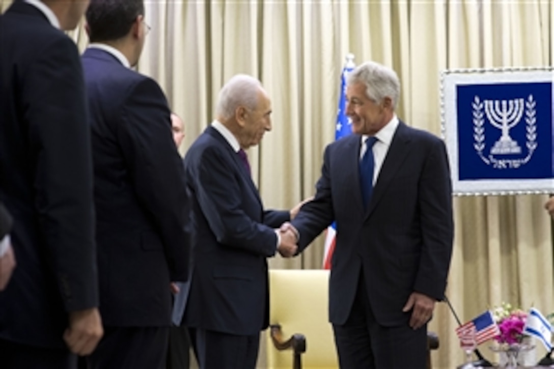 U.S. Defense Secretary Chuck Hagel, left, shakes hands with Israeli President Shimon Peres in Jerusalem May 16, 2014. The two met to discuss issues of mutual importance before laying wreaths at the graves of Theodor Herzl and Prime Minister Rabin to commemorate Israeli Independence Day.  