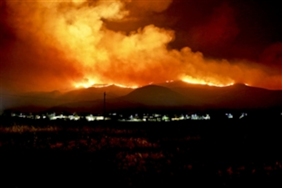 Marines and a fire crew respond to wildfires ablaze on Marine Corps Base Camp Pendleton, Calif., May 15, 2014. The Tomahawk fire, in the northeast section of Camp Pendleton, has burned more than 6,000 acres, forcing evacuations of housing areas on base and various schools on and off base. Aircraft from 3rd Marine Aircraft Wing and the Camp Pendleton Fire Department worked with state officials to prevent fires from spreading off base.