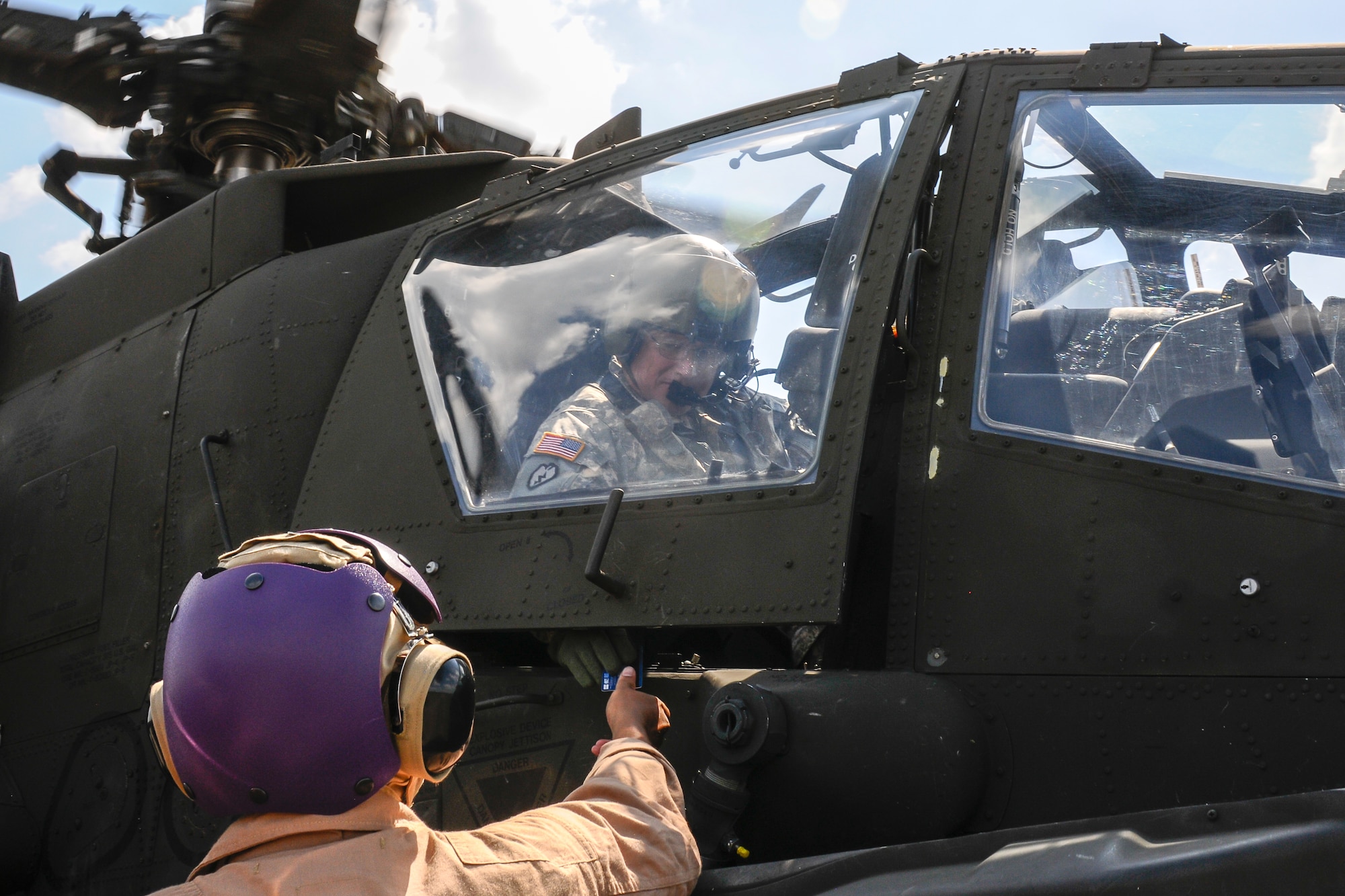 A U.S. Army AH-64 Apache pilot pays for fuel which is provided by U.S. Marines assigned to 273rd Marine Wing Support Squadron, Air Operations Company, during forward air refueling point operations at McEntire Joint National Guard Base, S.C. on May 14, 2014. Elements of the South Carolina Air and Army National Guard and the U.S. Marines conduct joint operations which are crucial to the ongoing success of operational readiness and deployments around the world.  (U.S. Air National Guard photo by Tech Sgt. Jorge Intriago/Released)