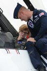 Maj. Mike Fisher, an advance pilot and narrator for the United States Air Force Thunderbirds aerial demonstration team shows Kalea Hall, a Reporter for the Youngstown Vindicator, the important features of the cockpit of Thunderbird number eight prior to take-off May 16, 2014, here. Hall flew with the Thunderbirds on a media flight in the only two-seat F-16 aircraft on the team. The flight was part of air show week activities leading up to the Thunder Over the Valley Air Show and Open House May 17 and 18. U.S. Air Force photo/Tech. Sgt. Jim Brock