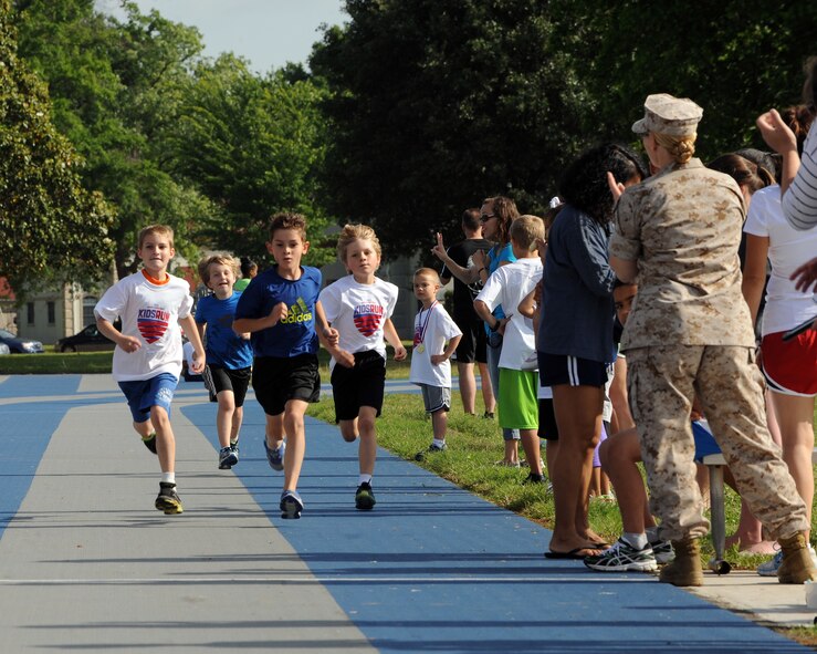 Children are cheered on during a one-mile Kids Run on Barksdale Air Force Base, La., May 17, 2014. The Kids Run is an annual fun run held on U.S. military installations around the world. (U.S. Air Force photo/Senior Airman Benjamin Gonsier)