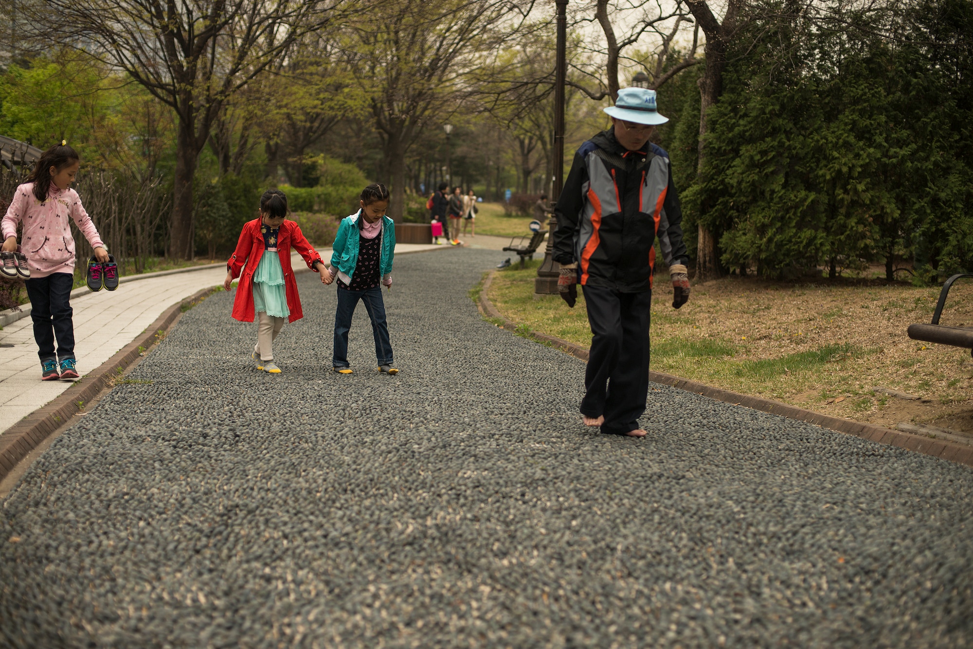 People walk across pointy rocks in Yeouido Park April 12, 2014, in Seoul, Republic of Korea. Walking across the harsh rocks are suppossed to massage and ultimately relax feet muscles. (U.S. Air Force photo by Staff Sgt. Jake Barreiro)