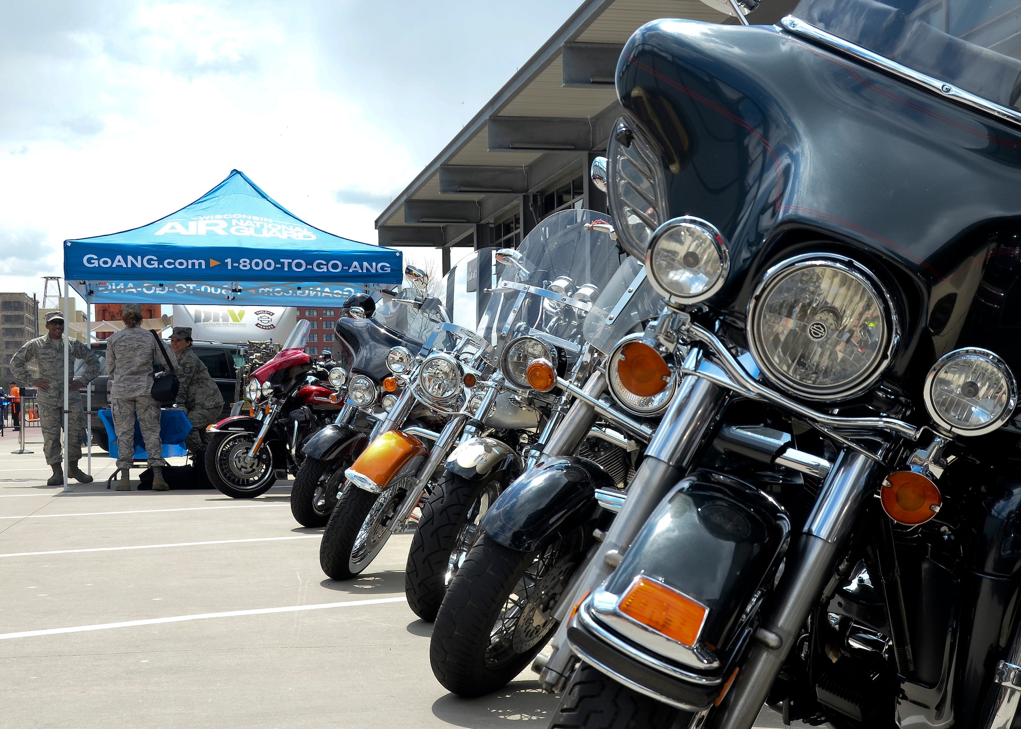 A group of motorcycles remain ready for their riders to drive away as they are parked next to the Air National Guard information stand at an Armed Forces Day event, Milwaukee, May 17, 2014. (U.S. Air National Guard photo by Airman Morgan R. Lipinski/Released)