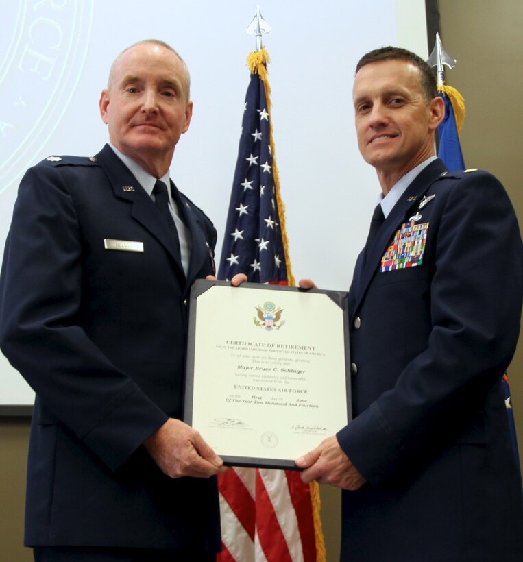 Lt. Col. Michael Nelson formerly the Medical Readiness Officer at 932nd Aeromedical Evacuation Squadron, presents the retirement certificate to Maj. Bruce Schlager May 18, 2014 during a ceremony held in the 932nd Airlift Wing (AW) auditorium at Scott AFB, Ill. Maj. Schlager retired from the Air Force Reserve after nearly 32 years of service. He served the last 10 years at the 932nd AW.  (U.S. Air Force Photo/Staff. Sgt. Meiko Schill)