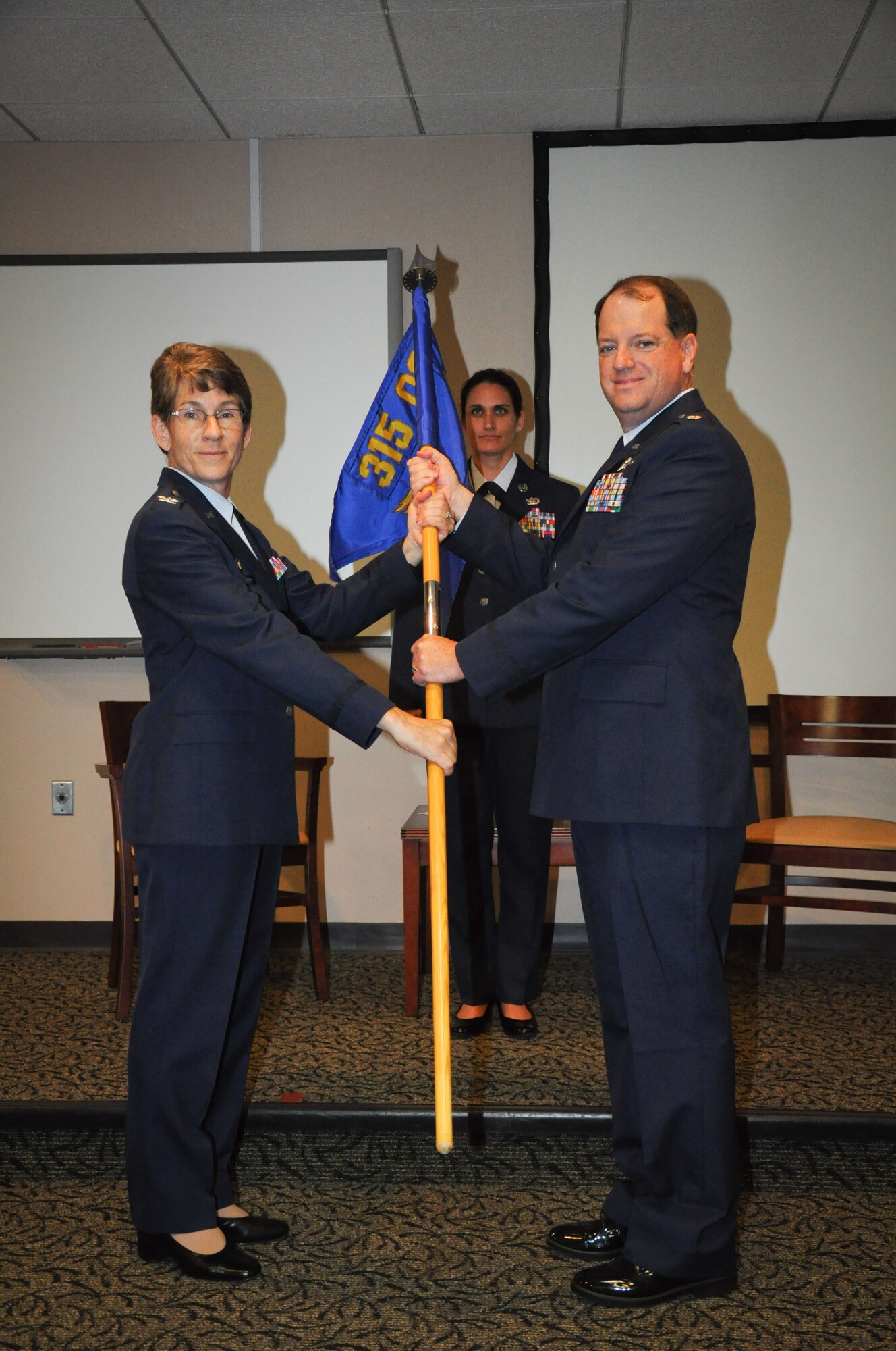 Col. Caroline Evernham, the 315th Operations Group commander here at Joint Base Charleston, S.C., presents the 315th Operations Support Squadron guidon to new 315th OSS commander Lt. Col. Thomas J. McNamara during an assumption of command ceremony today, in the Yonkie Auditorium here. (Photo by Senior Airman Bobby Pilch/released)