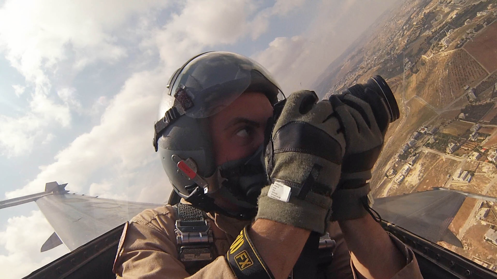 Staff Sgt. Roidan Carlson, 2d Combat Camera Squadron aerial combat broadcaster, prepares to take an aerial photo of a fighter jet formation over the country of Jordan, May 13, 2014. This flight was a joint mission between Royal Jordan Air Force, U.S. Air Force and U.S. Marine Corps aircraft during Exercise Eager Tiger and captured the partnership between U.S. and Jordan. (U.S. Air Force photo by Staff Sgt. Roidan Carlson/Released)