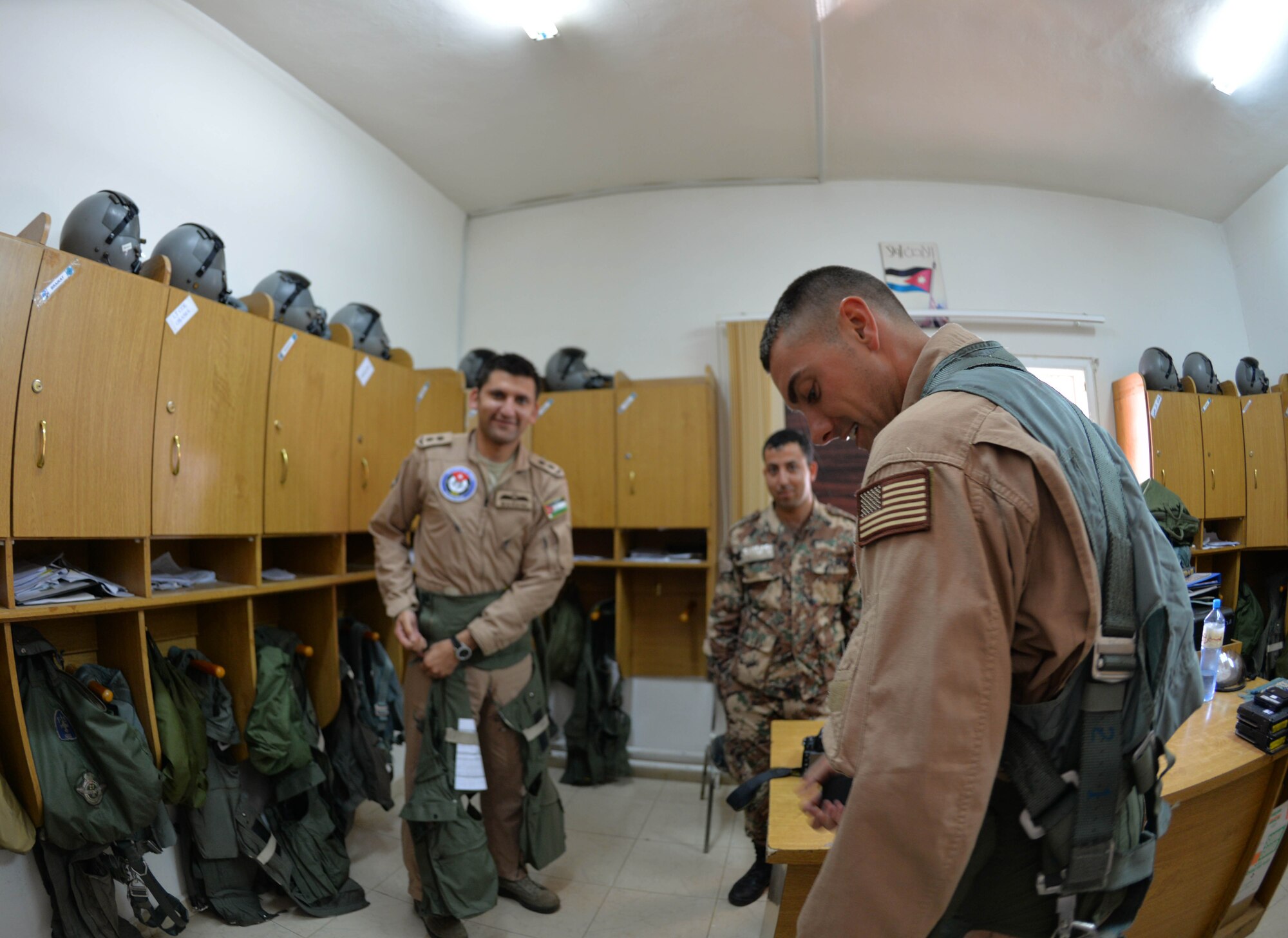 Staff Sgt. Roidan Carlson, 2d Combat Camera Squadron aerial combat broadcaster, adorns his flight gear to prepare for his flight with 1st Lt. Saddam Mardini, Royal Jordanian Air Force F-16 Fighting Falcon pilot May 13, 2014, at an air base in northern Jordan. This flight took place during Exercise Eager Tiger to capture the partnership between U.S. and Jordan. (U.S. Air Force photo by Capt. Sara Greco/Released)