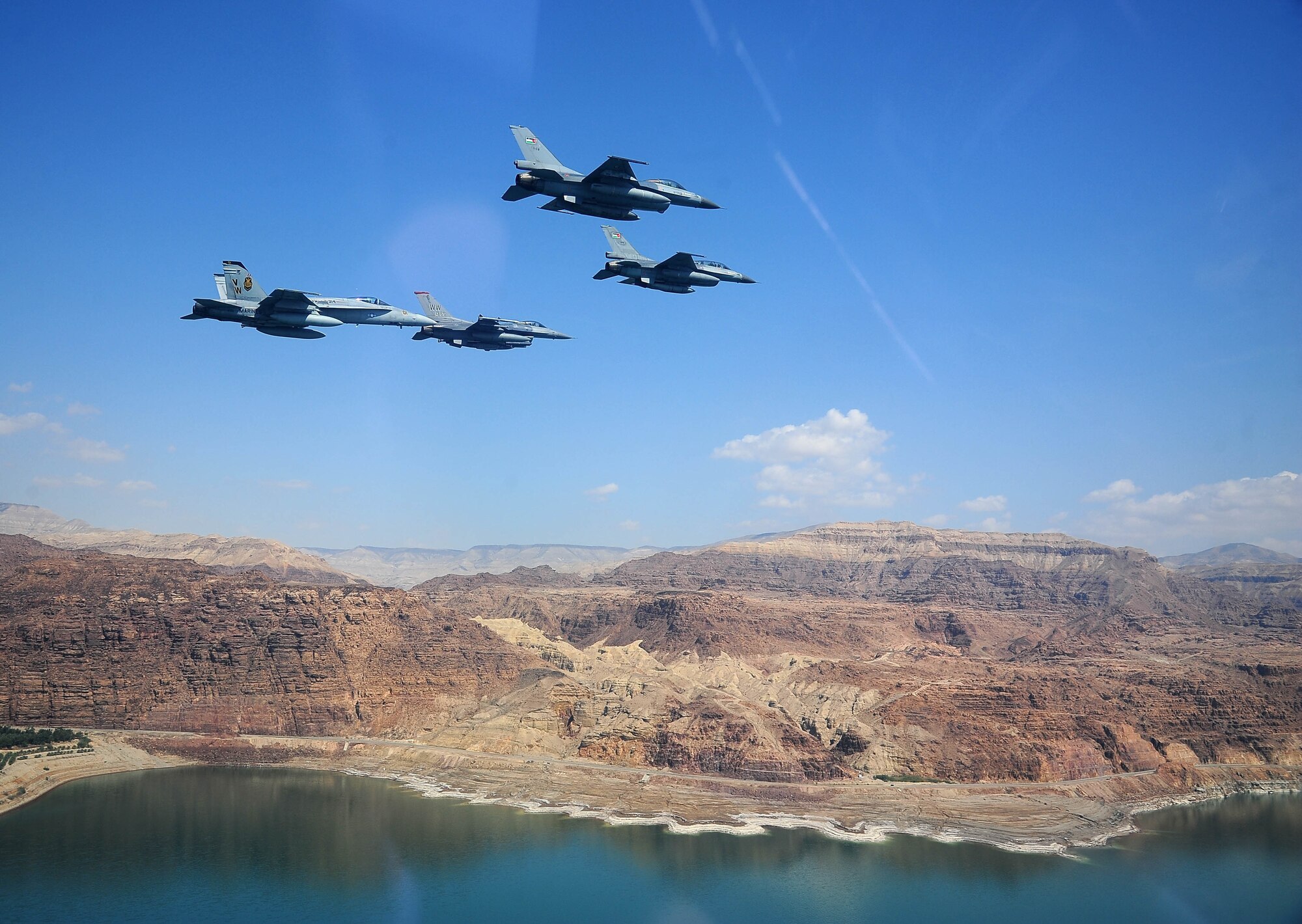 F-16 Fighting Falcons from the U.S. and Royal Jordanian air forces, as well as an F-18 Hornet from the U.S. Marine Corps, fly over the Dead Sea in Jordan May 13, 2014, during Exercise Eager Tiger. Hosted annually in Jordan, the exercise allows fighter pilots and maintainers from around the world to exchange knowledge while increasing interoperability and showing their dedication to regional stability. (U.S. Air Force photo by Staff Sgt. Roidan Carlson/Released)