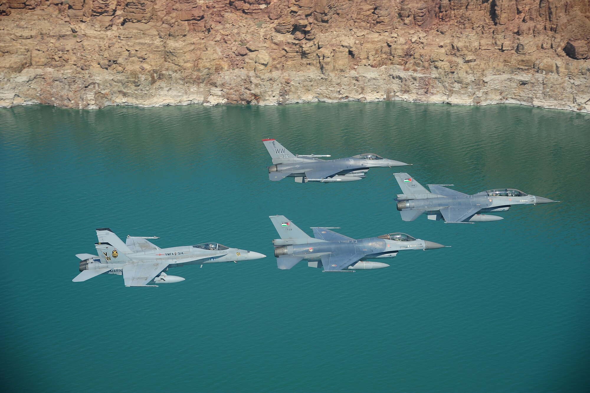 F-16 Fighting Falcons from the U.S. and Royal Jordanian air forces, as well as an F-18 Hornet from the U.S. Marine Corps, fly over the Dead Sea in Jordan May 13, 2014, during Exercise Eager Tiger. Hosted annually in Jordan, the exercise allows fighter pilots and maintainers from around the world to exchange knowledge while increasing interoperability and showing their dedication to regional stability. (U.S. Air Force photo by Staff Sgt. Roidan Carlson/Released)