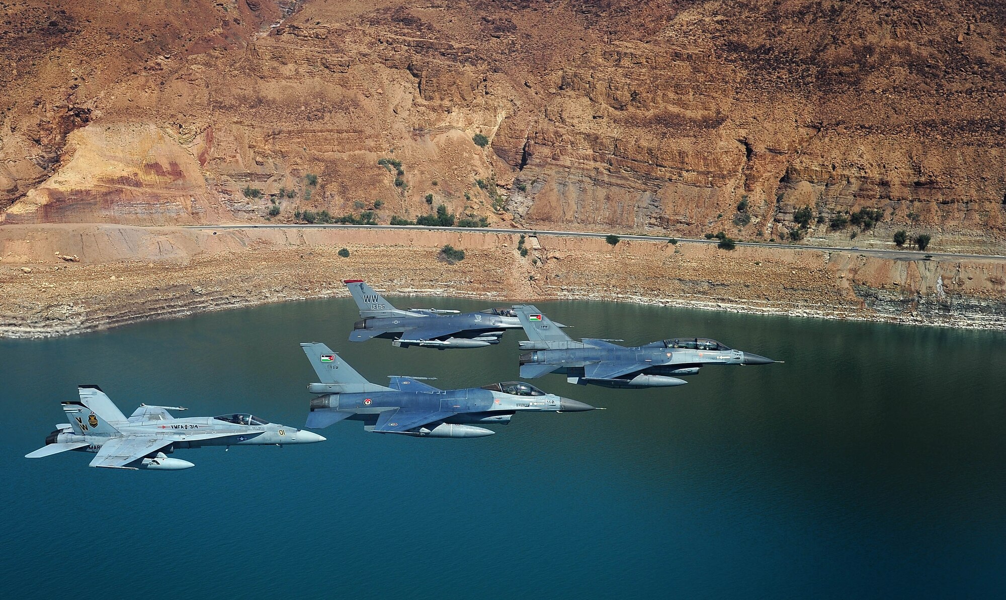 F-16 Fighting Falcons from the U.S. and Royal Jordanian air forces, as well as an F-18 Hornet from the U.S. Marine Corps, fly over the Dead Sea in Jordan May 13, 2014, during Exercise Eager Tiger. Hosted annually in Jordan, the exercise allows fighter pilots and maintainers from around the world to exchange knowledge while increasing interoperability and showing their dedication to regional stability. (U.S. Air Force photo by Staff Sgt. Roidan Carlson/Released)