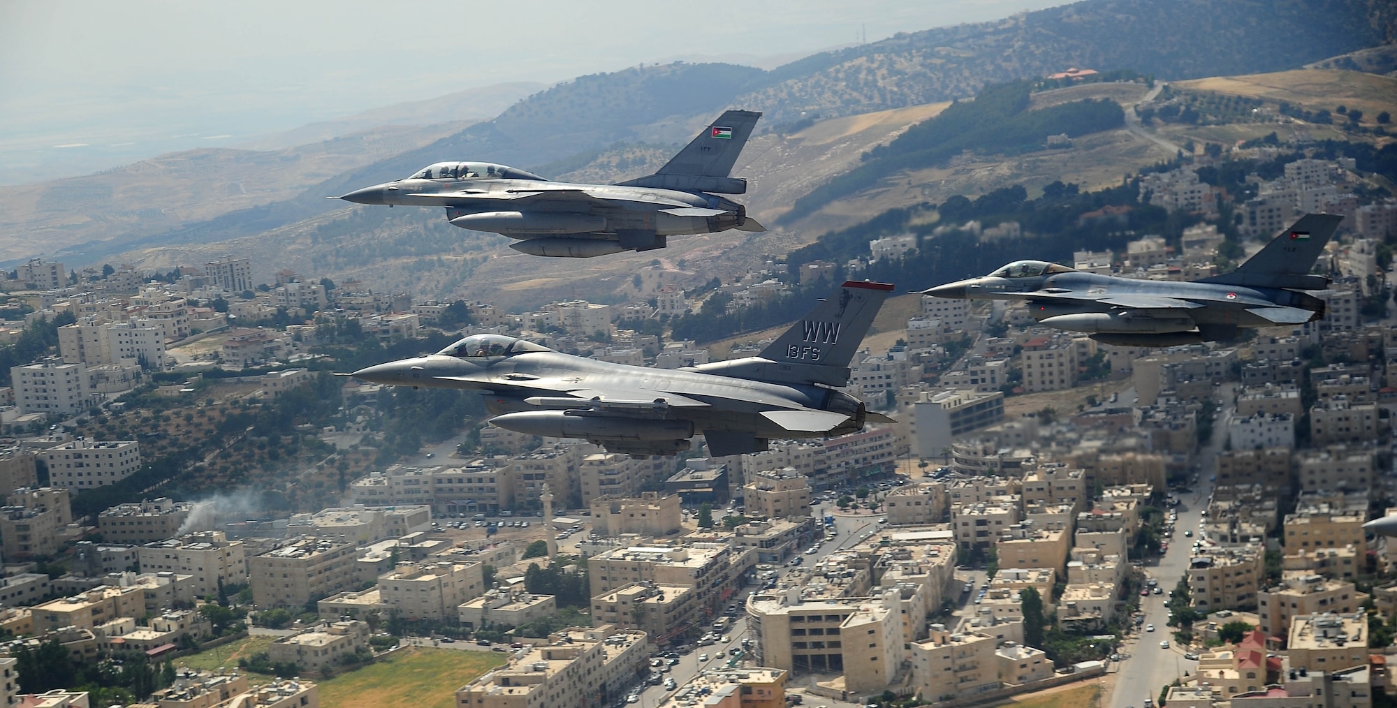 F-16 Fighting Falcons from the U.S. and Royal Jordanian air forces, as well as an F-18 Hornet from the U.S. Marine Corps, fly over Amman, Jordan, during Exercise Eager Tiger May 13, 2014. Hosted annually in Jordan, the exercise allows fighter pilots and maintainers from around the world to exchange knowledge while increasing interoperability and showing their dedication to regional stability. (U.S. Air Force photo by Staff Sgt. Roidan Carlson/Released)