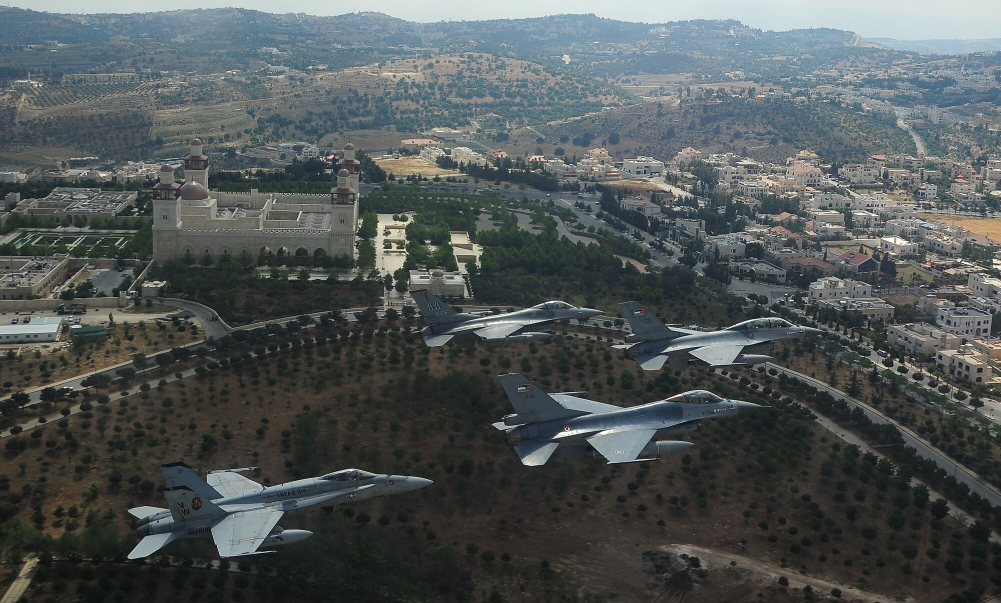 F-16 Fighting Falcons from the U.S. and Royal Jordanian air forces, as well as an F-18 Hornet from the U.S. Marine Corps, fly over the King Hussein Bin Talal Mosque in Amman, Jordan, during Exercise Eager Tiger May 13, 2014. Hosted annually in Jordan, the exercise allows fighter pilots and maintainers from around the world to exchange knowledge while increasing interoperability and showing their dedication to regional stability. (U.S. Air Force photo by Staff Sgt. Roidan Carlson/Released)