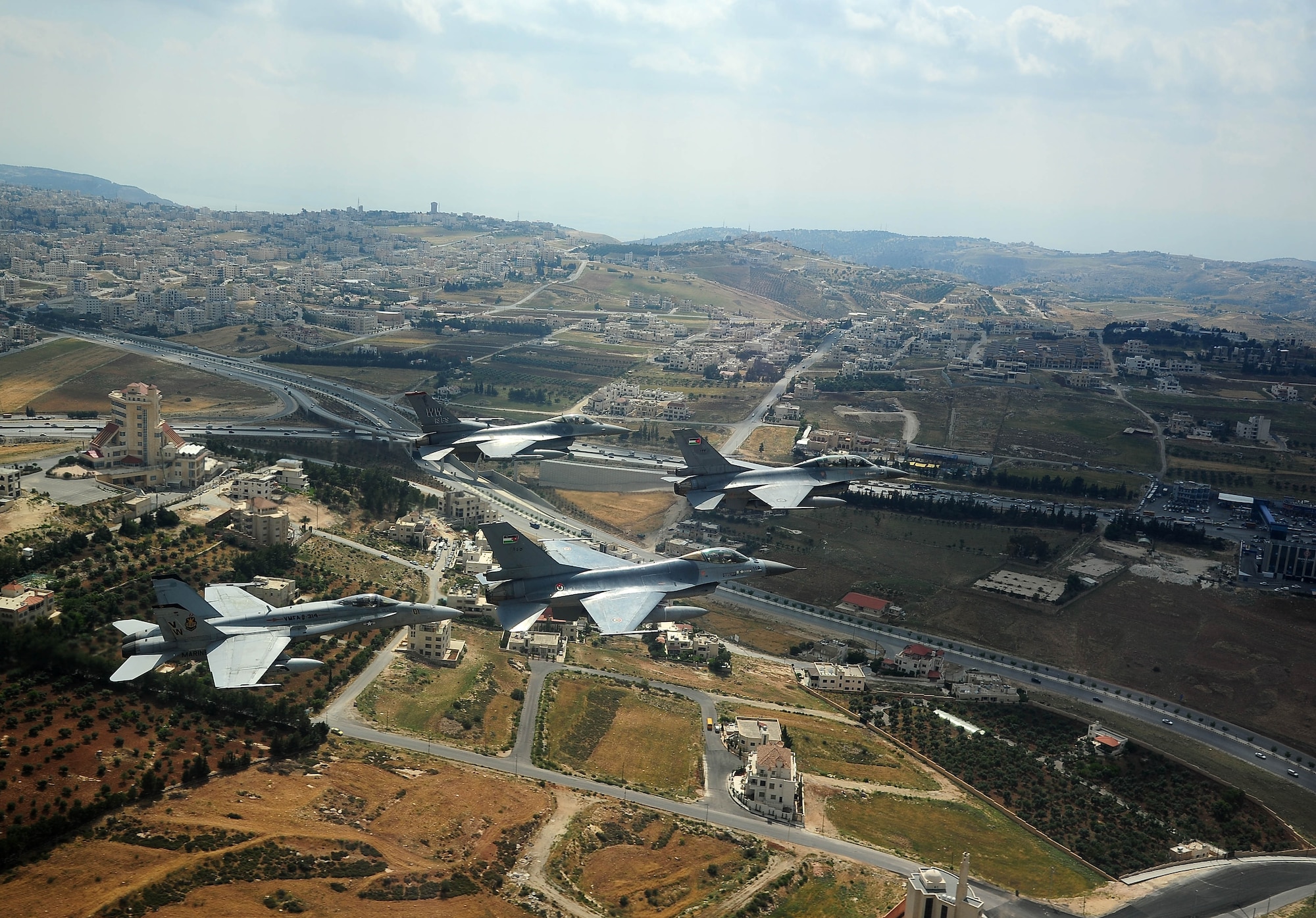 F-16 Fighting Falcons from the U.S. and Royal Jordanian air forces, as well as an F-18 Hornet from the U.S. Marine Corps, fly over Amman, Jordan, during Exercise Eager Tiger May 13, 2014. Hosted annually in Jordan, the exercise allows fighter pilots and maintainers from around the world to exchange knowledge while increasing interoperability and showing their dedication to regional stability. (U.S. Air Force photo by Staff Sgt. Roidan Carlson/Released)