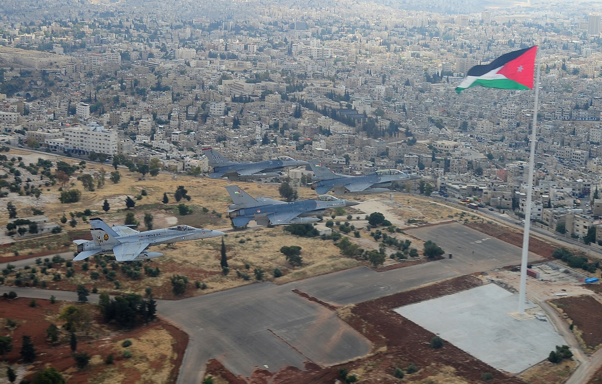 F-16 Fighting Falcons from the U.S. and Royal Jordanian air forces, as well as an F-18 Hornet from the U.S. Marine Corps, fly over Amman, Jordan, during Exercise Eager Tiger May 13, 2014. Hosted annually in Jordan, the exercise allows fighter pilots and maintainers from around the world to exchange knowledge while increasing interoperability and showing their dedication to regional stability. (U.S. Air Force photo by Staff Sgt. Roidan Carlson/Released)