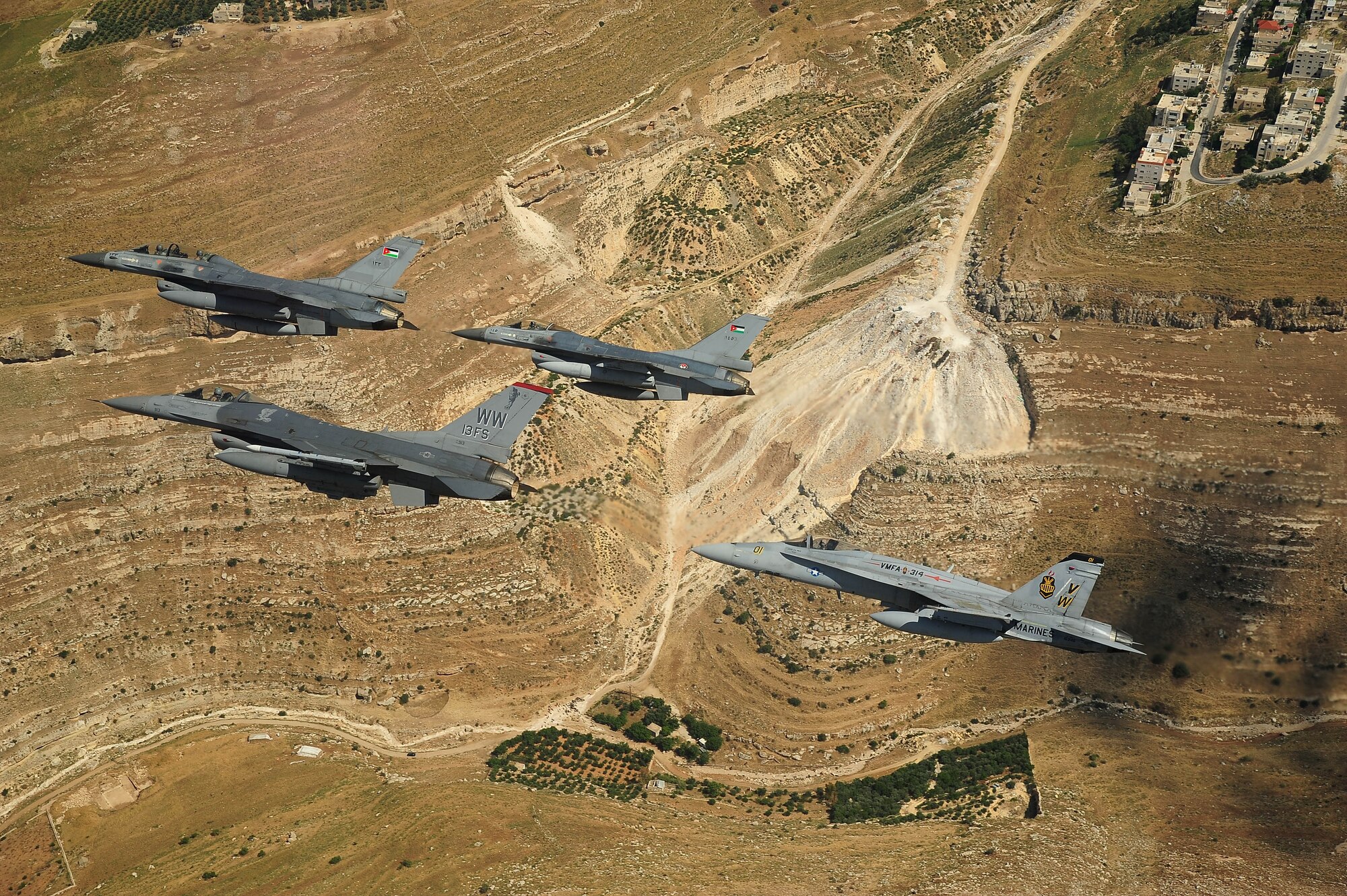 F-16 Fighting Falcons from the U.S. and Royal Jordanian air forces, as well as an F-18 Hornet from the U.S. Marine Corps, fly over Jordan May 13, 2014, during Exercise Eager Tiger. Hosted annually in Jordan, the exercise allows fighter pilots and maintainers from around the world to exchange knowledge while increasing interoperability and showing their dedication to regional stability. (U.S. Air Force photo by Staff Sgt. Roidan Carlson/Released)