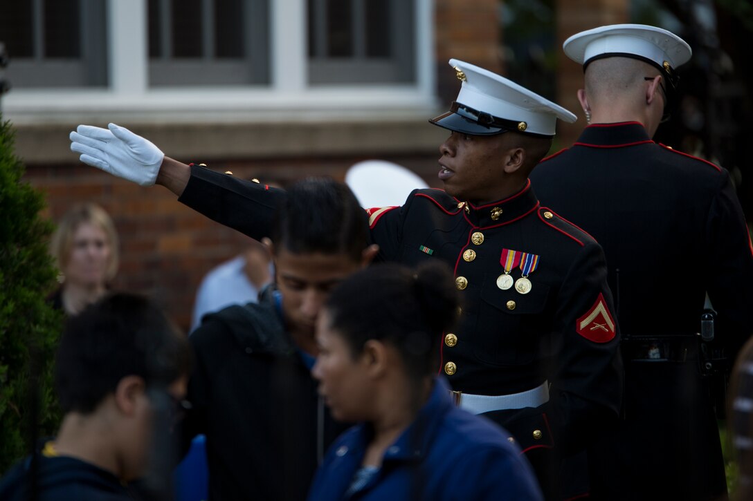 Lance Cpl. Marshall Walker, ceremonial host, guides guests prior to a Friday Evening Parade at Marine Barracks Washington, D.C., May 16. (Official Marine Corps photo by Cpl. Larry Babilya/Released)