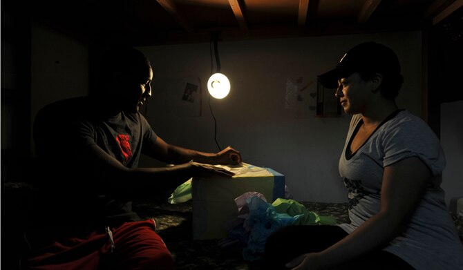 Senior Airman Shawn Brock opens an anniversary gift from his wife, Hillary, right, May 15, 2014, in Southwest Asia. The Brocks celebrated their first wedding anniversary while deployed. Both serve as firefighters with the 380th Expeditionary Civil Engineer Squadron. (U.S. Air Force photo/Tech. Sgt. Russ Scalf)