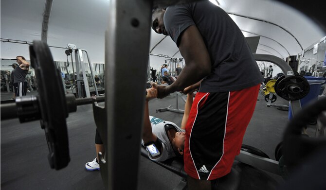 Senior Airman Shawn Brock works out with his wife, Hillary, May 15, 2014, in Southwest Asia. The couple spent their first anniversary much like they would any other day on their deployment. Shawn and Hillary are 380th Expeditionary Civil Engineer Squadron firefighters. (U.S. Air Force photo/Tech. Sgt. Russ Scalf)