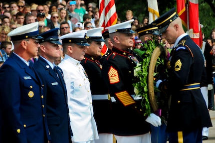 Marine Corps Sgt. Maj. Bryan B. Battaglia, fifth from left, senior enlisted advisor to the chairman of the Joint Chiefs of Staff, receives assistance from a soldier assigned to the 3rd U.S. Infantry Regiment, known as "The Old Guard," during a wreath laying ceremony at the Tomb of the Unknown Soldier to mark Armed Forces Day at Arlington National Cemetery in Arlington, Va., May 17, 2014.