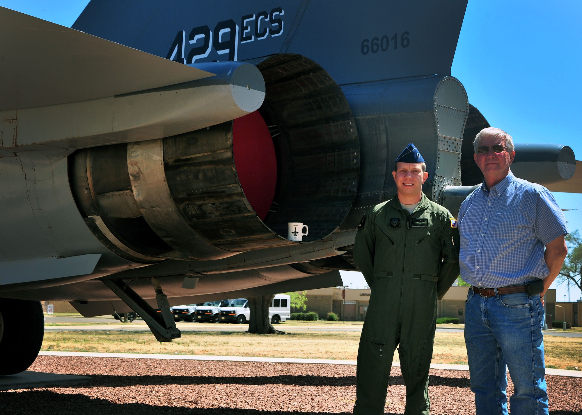 Capt. Christopher Smoak and his father, Cameron Smoak, stand next to an F-111A Aardvark display May 9, 2014, at Cannon Air Force Base, N.M. Cameron crewed the airframe during the 1970s. The father and son searched for the tail numbers Cameron was responsible for many years before discovering 66-016 on display at Cannon AFB. Christopher is a pilot with the 318th Special Operations Squadron.  (U.S. Air Force photo/Staff Sgt. Whitney Amstutz)