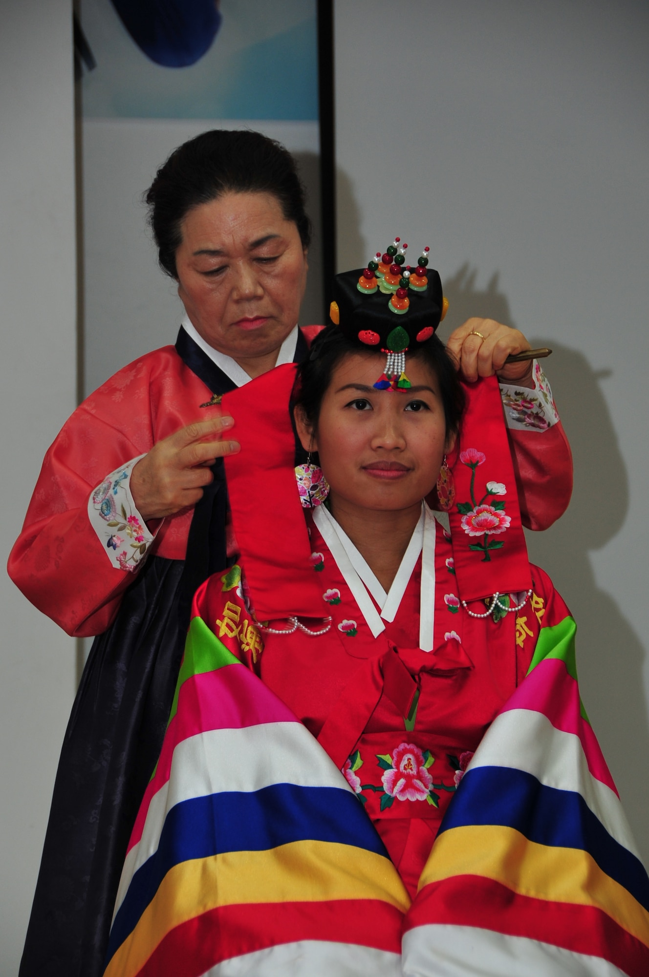 PYEONGTAEK, Republic of Korea - A Pyeongtaek University culture instructor dresses Osan Air Base spouse Suchada Sepassi in a traditional Korean wedding dress during a culture class at Pyeongtaek University May 16, 2014. The class was part of the 7th Air Force Head Start Program designed to teach newcomers about Korean culture and language. (U.S. Air Force photo by Tech. Sgt. Thomas J. Doscher)