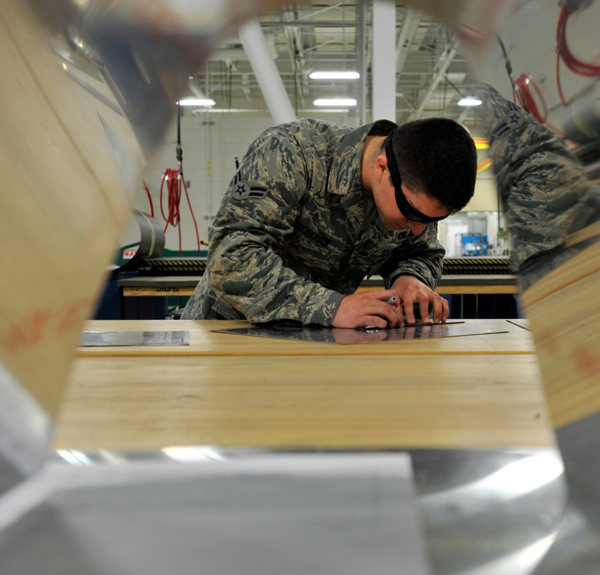 Airman 1st Class Devid Doronin, 3rd Maintenance Squadron aircraft structural maintenance apprentice, measures sheet metal to repair an aircraft on Joint Base Elmendorf-Richardson, Alaska, May 8, 2014. The Fabrication Flight personnel assess and fix small and large parts on aircraft that come and go from JBER’s airfield to keep the mission running and the personnel safe. (U.S. Air Force photo/Airman 1st Class Tammie Ramsouer)