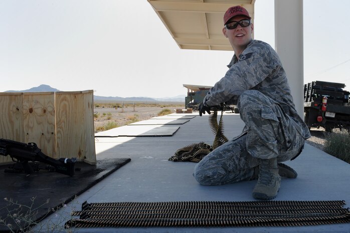 U.S. Air Force Staff Sgt. Michael Zema, 99th Security Forces Squadron combat arms instructor, lays out belts of 5.56 mm ammunition in preparation of a familiarization event for base leadership as part of National Police Week May 15, 2014, at Nellis Air Force Base, Nev. National Police Week is celebrated during the week of May 15 during which all police forces are honored. (U.S. Air Force photo by Tech. Sgt. Taylor Worley)