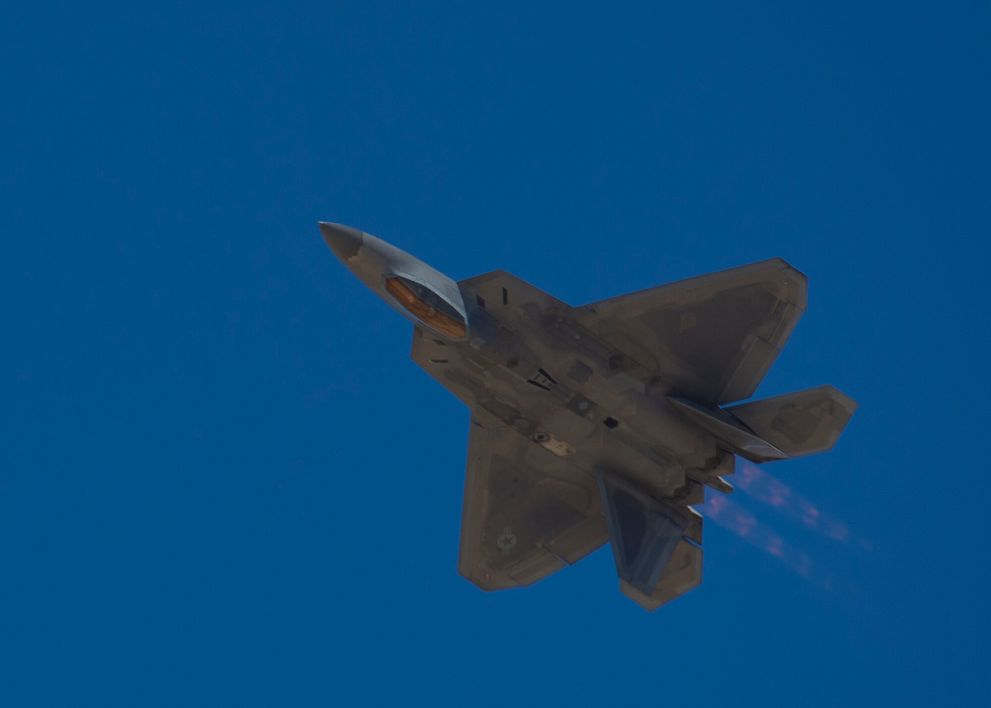 An F-22 Raptor demonstrates its capabilities during the Open House event at Holloman Air Force Base, N.M., May 10. Team Holloman hosted an Open House showcasing over 50 aircraft and the day-to-day duties of Holloman Airmen. With live flying demonstrations and static displays, thousands of guests attended the event to get a close-up look at the base’s assets and capabilities. Guests were able to view various aircraft, visit numerous vendors, and witness ground demonstrations from squadrons around the base. (U.S. Air Force photo by Airman 1st Class Aaron Montoya / Released)