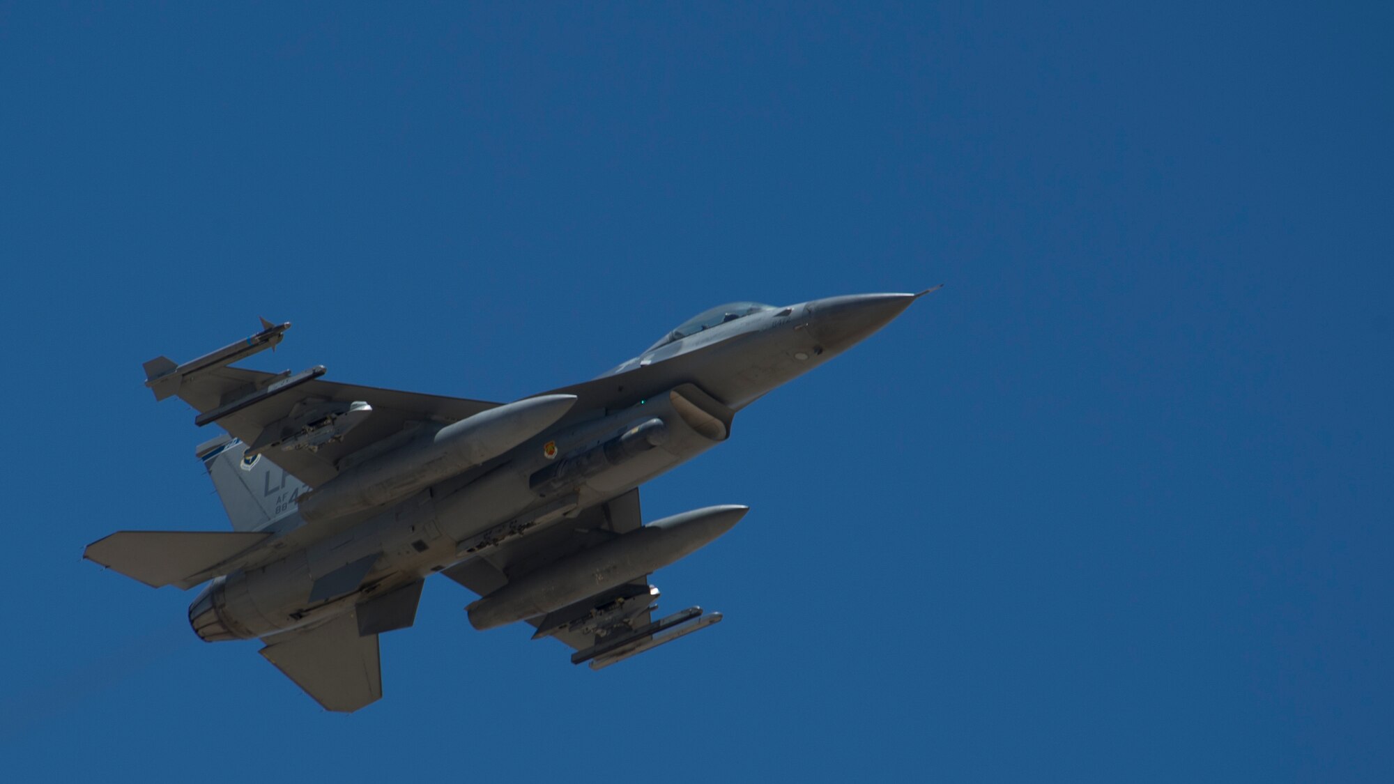 An F-16 Fighting Falcon soars through the skies of the Tularosa Basin during the Open House event at Holloman Air Force Base, N.M., May 10. Team Holloman hosted an Open House showcasing over 50 aircraft and the day-to-day duties of Holloman Airmen. With live flying demonstrations and static displays, thousands of guests attended the event to get a close-up look at the base’s assets and capabilities. Guests were able to view various aircraft, visit numerous vendors, and witness ground demonstrations from squadrons around the base. (U.S. Air Force photo by Airman 1st Class Aaron Montoya / Released)