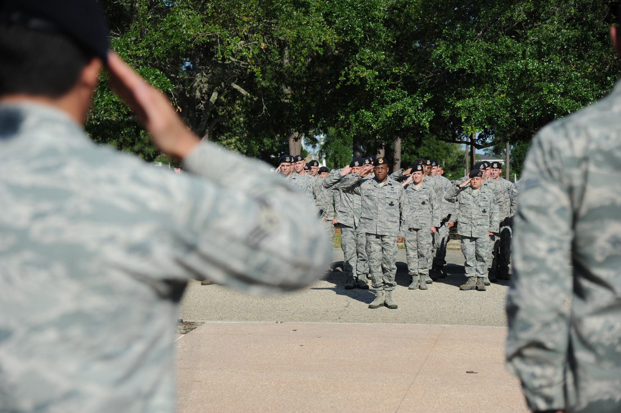 Maj. T.C. McIntosh, 81st Security Forces Individual Mobility Augmentee, and members of the 81st Security Forces Squadron render a salute during a retreat ceremony hosted by the 81st SFS May 15, 2014, at Keesler Air Force Base, Miss.  The retreat ceremony was held in memory of all law enforcement officers in the State of Mississippi, Air Force Officers of Special Investigations and 81st SFS members who have lost their lives in the line of duty over the past year.  (U.S. Air Force photo by Kemberly Groue)