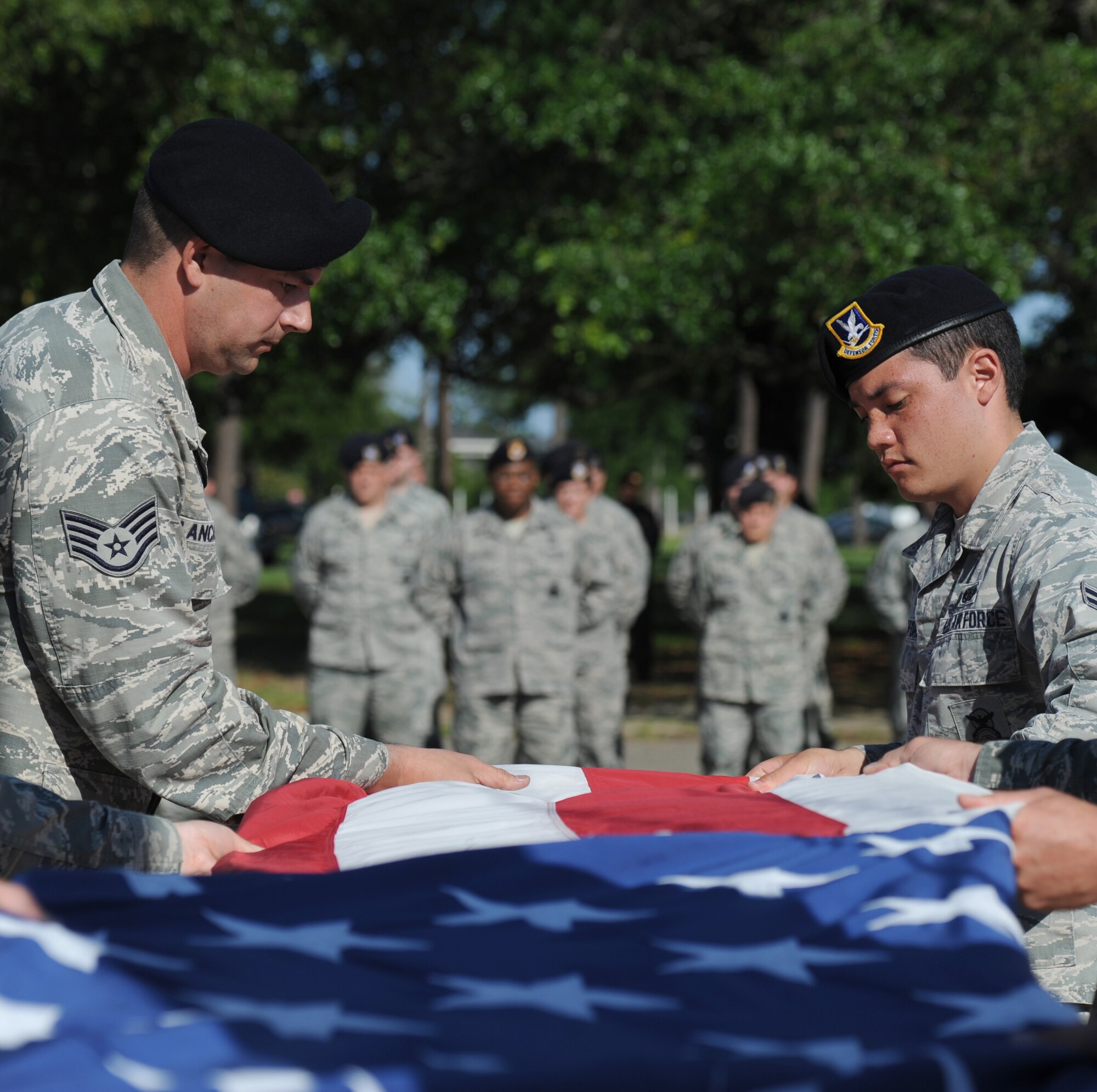 Staff Sgt. Richard Lancaster and Airman 1st Class Matthew Ratchford, 81st Security Forces Squadron, conduct a flag folding ceremony during a retreat ceremony hosted by the 81st SFS May 15, 2014, at Keesler Air Force Base, Miss.  The retreat ceremony was held in memory of all law enforcement officers in the State of Mississippi, Air Force Officers of Special Investigations and 81st SFS members who have lost their lives in the line of duty over the past year.  (U.S. Air Force photo by Kemberly Groue)