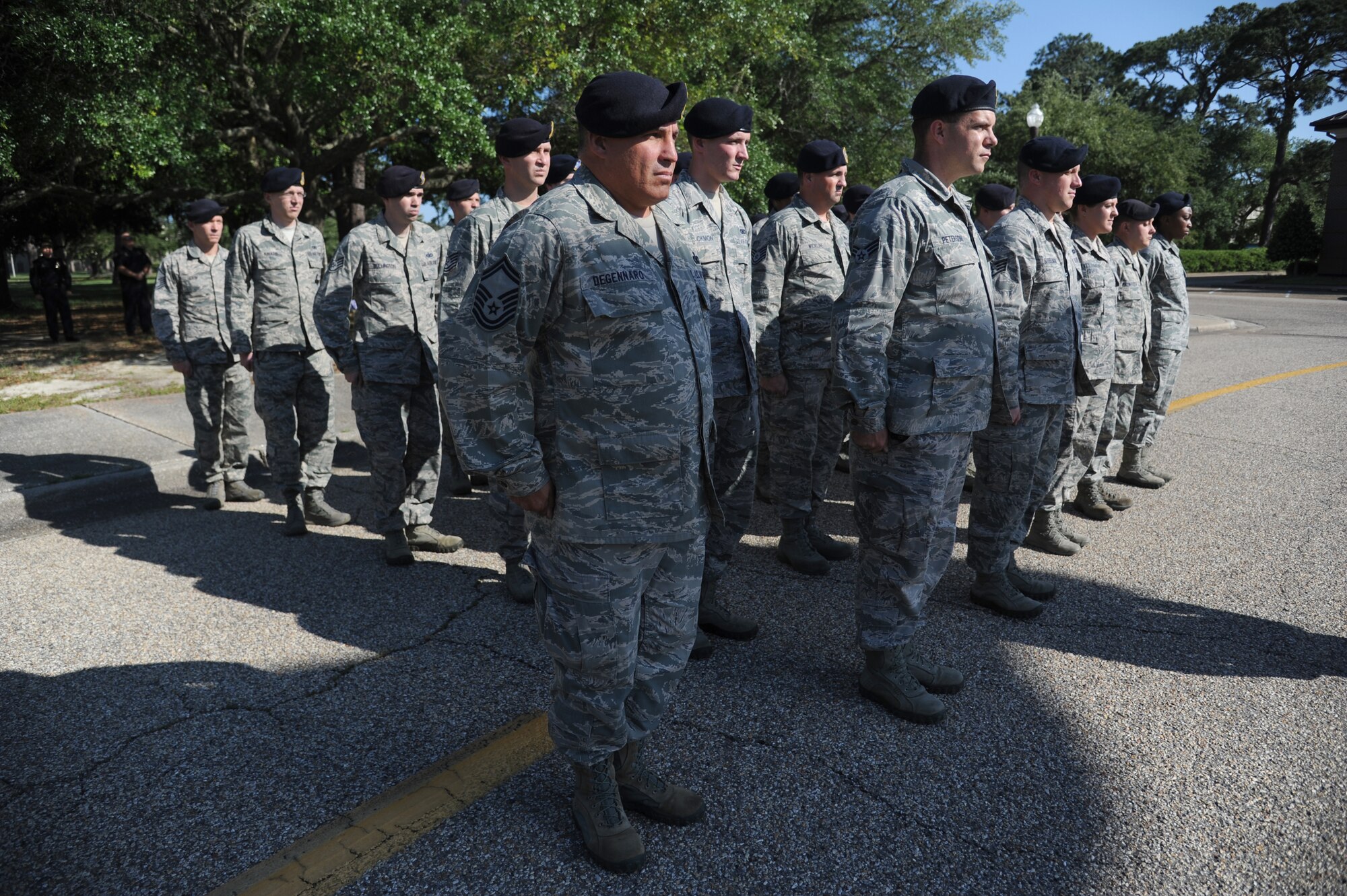 Senior Master Sgt. Robert Degennaro, 81st Security Forces Squadron, and members of the 81st SFS stand at attention as the U.S. flag is lowered during a retreat ceremony hosted by the 81st SFS May 15, 2014, at Keesler Air Force Base, Miss.  The retreat ceremony was held in memory of all law enforcement officers in the State of Mississippi, Air Force Officers of Special Investigations and 81st SFS members who have lost their lives in the line of duty over the past year.  (U.S. Air Force photo by Kemberly Groue)