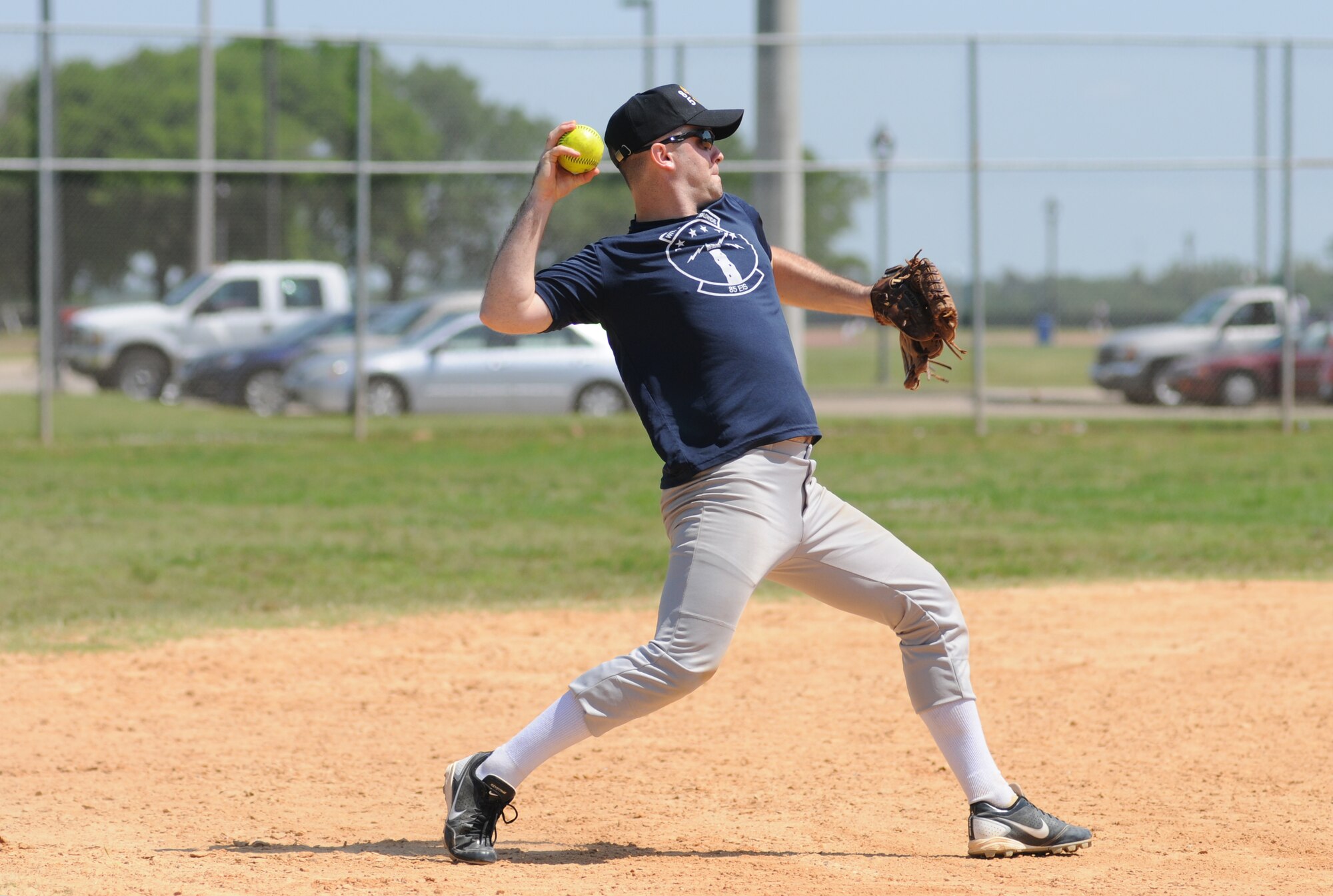 Second Lt. Jacob Partain, 85th Engineering Installation Squadron, makes a successful throw to first base during a softball tournament hosted by the 81st Security Forces Squadron May 16, 2014, at Keesler Air Force Base, Miss.  The softball tournament was held in celebration of National Police Week, which recognizes the service of men and women who put their lives at risk every day. (U.S. Air Force photo by Kemberly Groue)