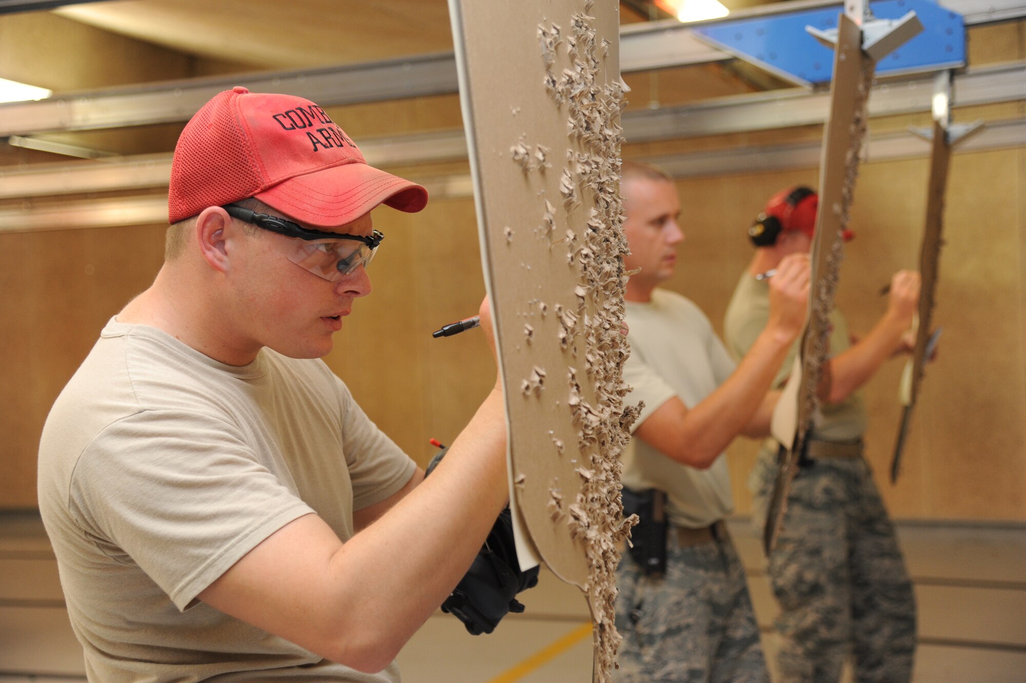 Tech. Sgt. Jonathan Abston, 81st Security Forces Squadron, and other combat arms members calculate the scores on targets during the pistol competition hosted by the 81st SFS May 13, 2014, at the indoor firing range, Keesler Air Force Base, Miss.  The pistol competition was held during National Police Week, which recognizes the service of men and women who put their lives at risk every day. (U.S. Air Force photo by Kemberly Groue)