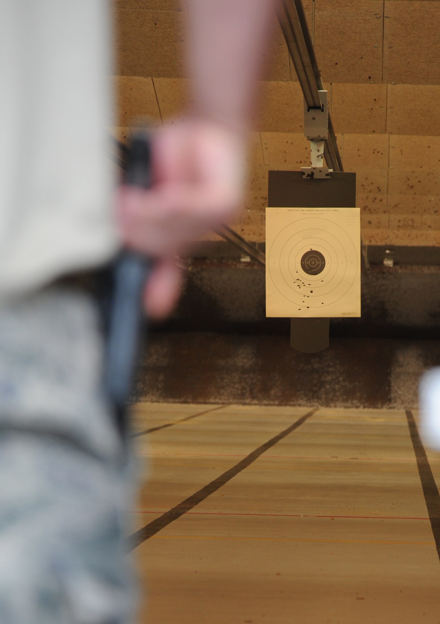 Maj. Brian Fitzpatrick, 81st Security Forces Squadron commander, keeps his hand on his weapon while waiting for the start of the pistol competition hosted by the 81st SFS May 13, 2014, at the indoor firing range, Keesler Air Force Base, Miss.  The pistol competition was held during National Police Week, which recognizes the service of men and women who put their lives at risk every day. (U.S. Air Force photo by Kemberly Groue)