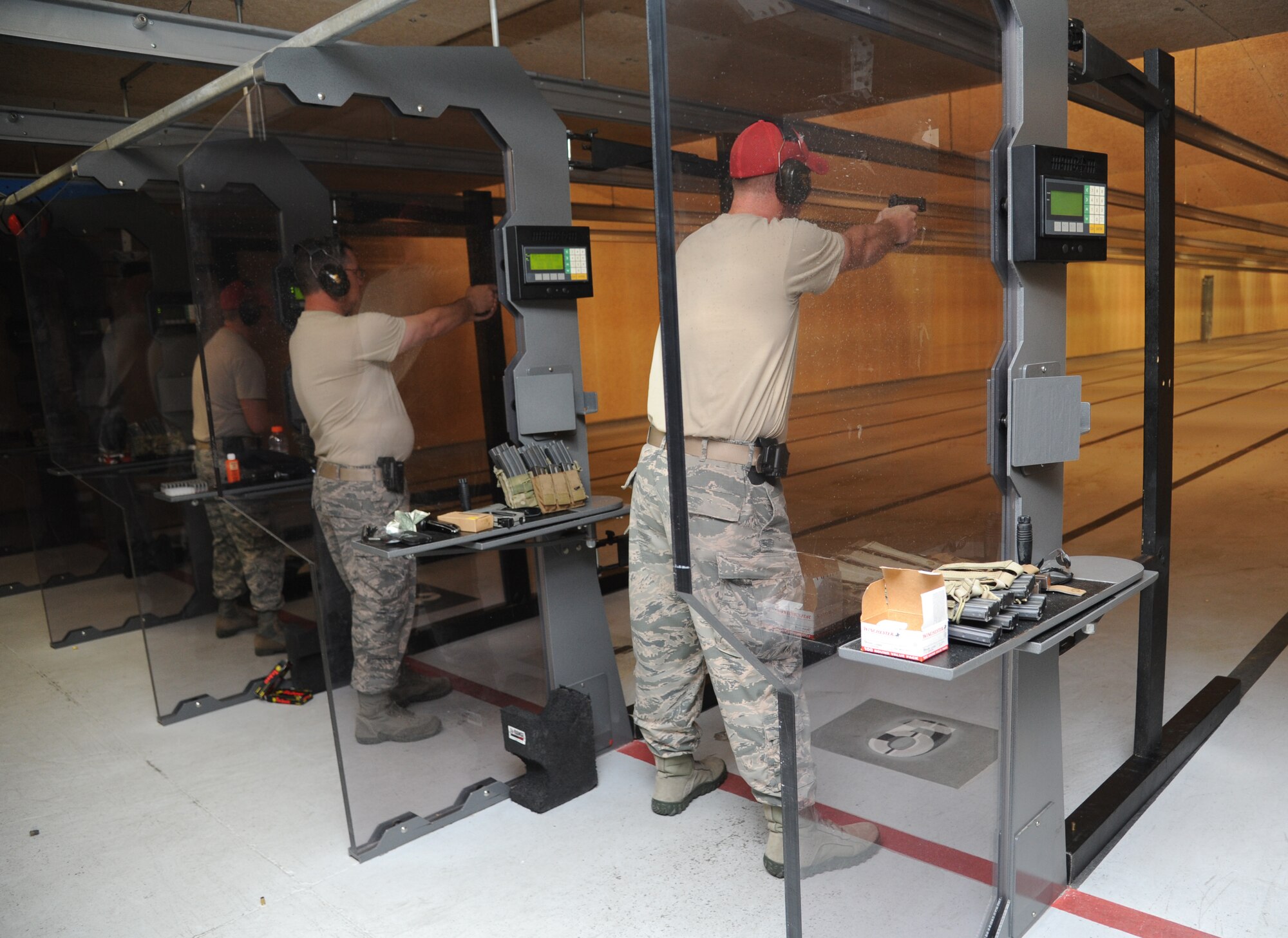 Master Sgt. Barry Hardy and Staff Sgt. Michael O’Neil, 81st Security Forces Squadron, fire their pistols at targets during a pistol competition hosted by the 81st SFS May 13, 2014, at the indoor firing range, Keesler Air Force Base, Miss.  The pistol competition was held during National Police Week, which recognizes the service of men and women who put their lives at risk every day. (U.S. Air Force photo by Kemberly Groue)