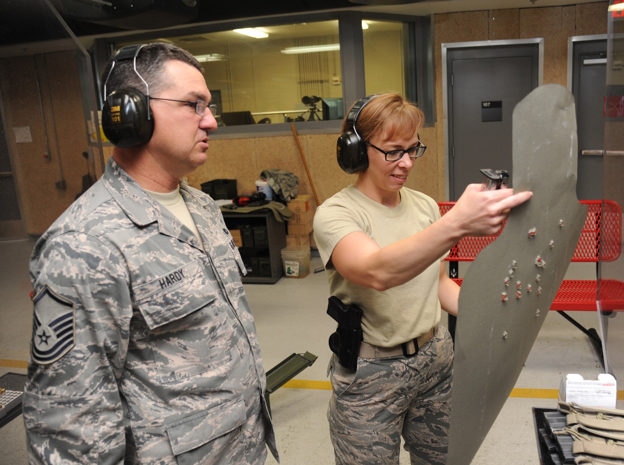 Master Sgts. Barry Hardy and Casy Boomershine, 81st Security Forces Squadron, inspect her target for a number of hits she made while firing her pistol during a pistol competition hosted by the 81st SFS May 13, 2014, at the indoor firing range, Keesler Air Force Base, Miss.  The pistol competition was held during National Police Week, which recognizes the service of men and women who put their lives at risk every day. (U.S. Air Force photo by Kemberly Groue)