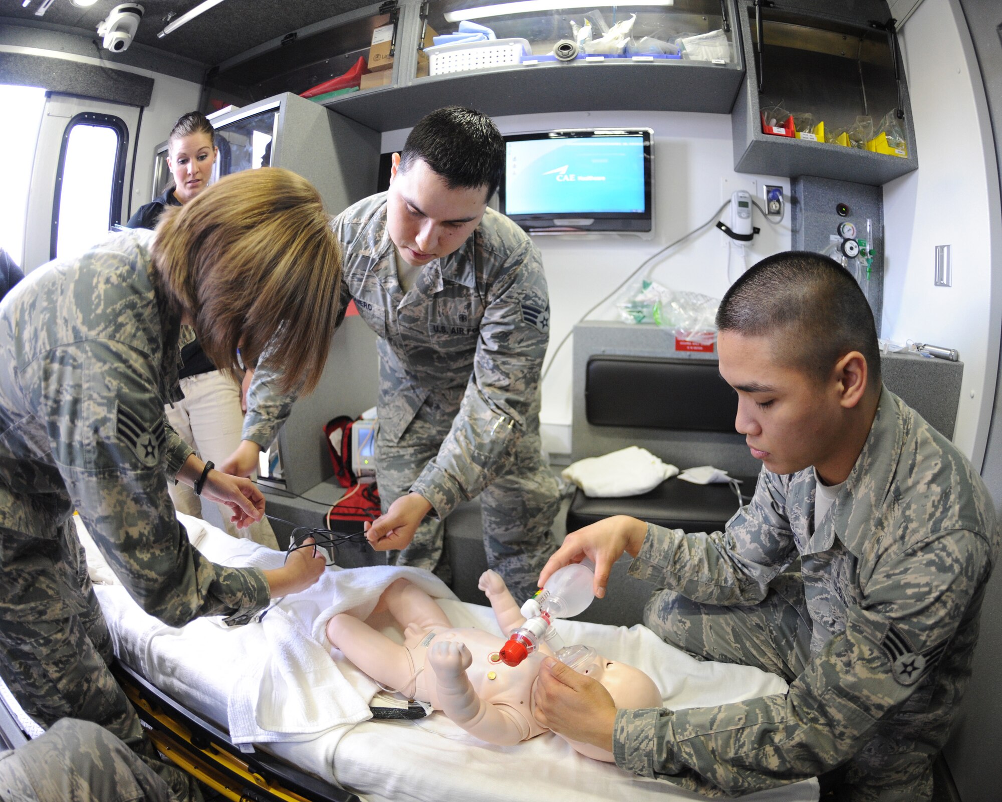 Members of the 319th Medical Group provide medical support to a newborn mannequin during a training simulation on May 16, 2014, at Grand Forks Air Force Base, N.D. Simulation in Motion - North Dakota uses scenarios with a high mortality rate to create an intense environment and test participants abilities to react in stressful situations. (U.S. Air Force photo/Senior Airman Zachiah Roberson)
