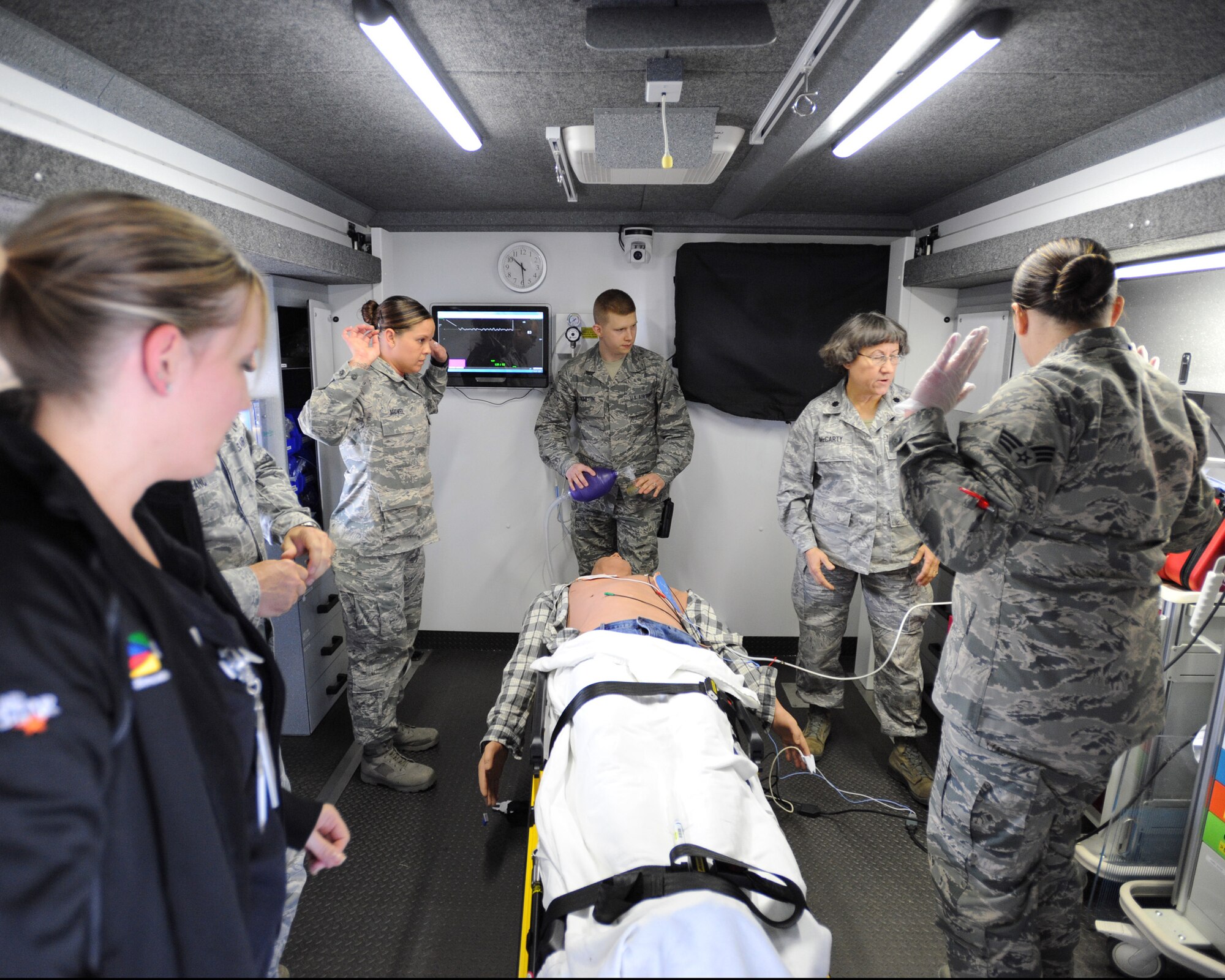 Members of the 319th Medical Group take the correct safety precautions during the defibrillation of a fully responsive test mannequin during a training simulation on May 16, 2014, at Grand Forks Air Force Base, N.D. The 319th MDG members were observed by emergency responders and other medical professionals from Altru Hospital in Grand Forks N.D. (U.S. Air Force photo/Senior Airman Zachiah Roberson)