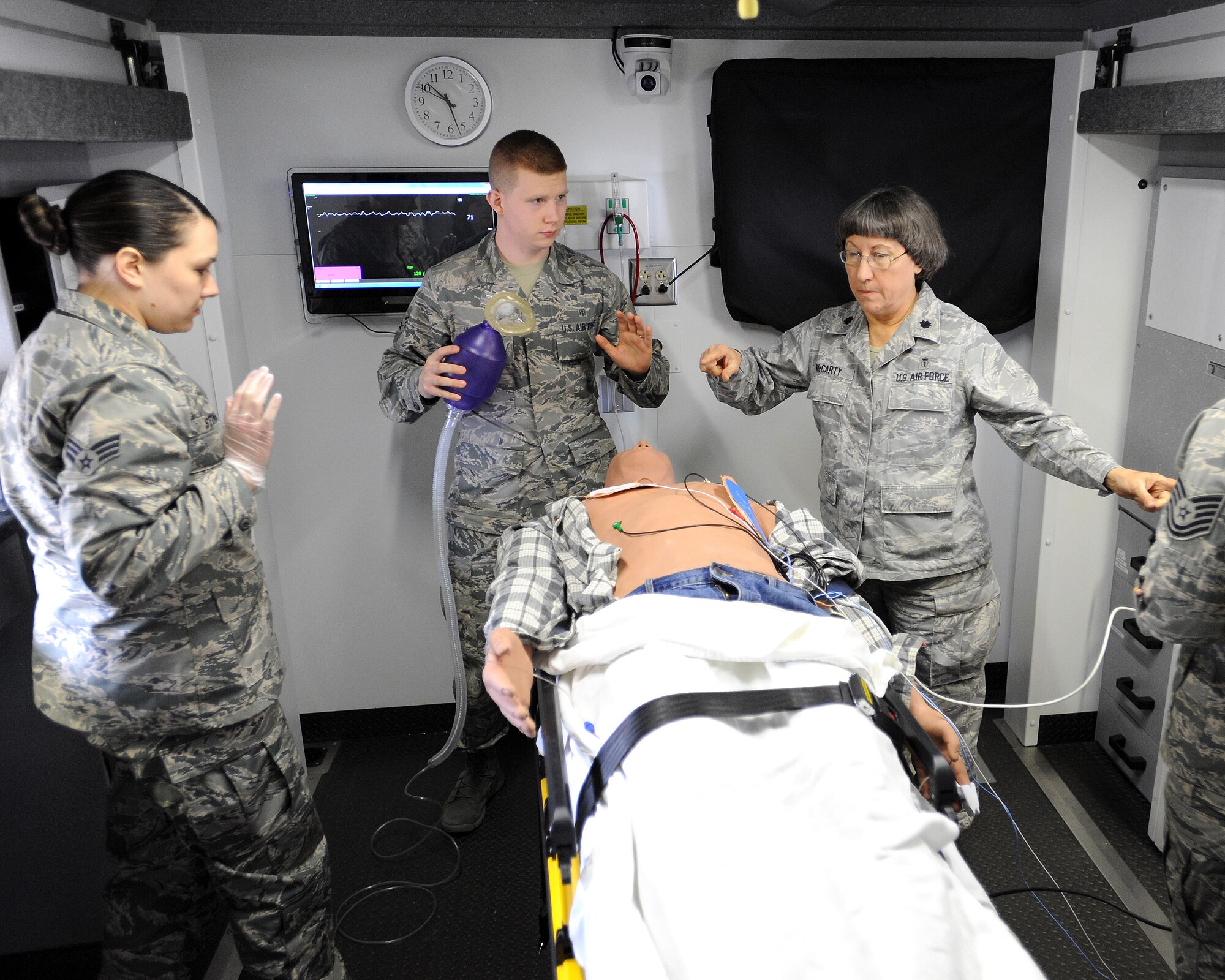 Members of the 319th Medical Group conduct multiple methods of treatment to a fully responsive test mannequin during a training simulation on May 16, 2014, at Grand Forks Air Force Base, N.D. Simulation in Motion - North Dakota came to Grand Forks AFB to give base medical responders a chance to test their skills on fully responsive, state-of-the-art dummy’s portraying actual possible medical emergencies. (U.S. Air Force photo/Senior Airman Zachiah Roberson)