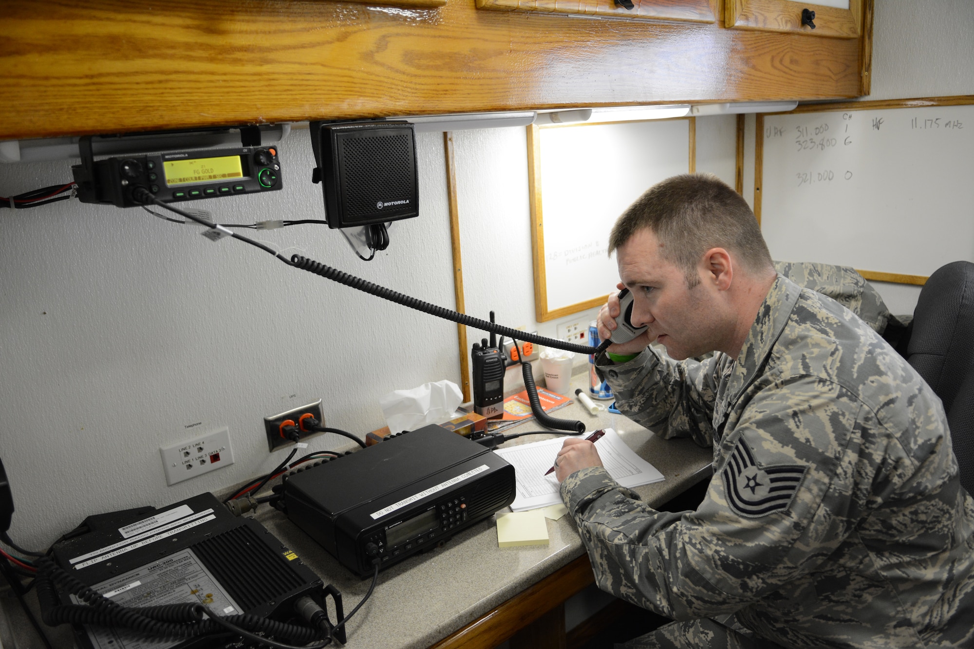 Tech. Sgt. Nathan Thrun, 128th Emergency Management program manager, listens to his radio during an exercise at the 2014 State Interoperable Mobile Communications Exercise in Oshkosh, Wis., May 15, 2014. Members of the Wisconsin National Guard tested their ability to communicate with other agencies. The 128th ARW also tested their ability to communicate with those in helicopters flying above the exercise site. (Air National Guard photo by Senior Airman Andrea F. Liechti)