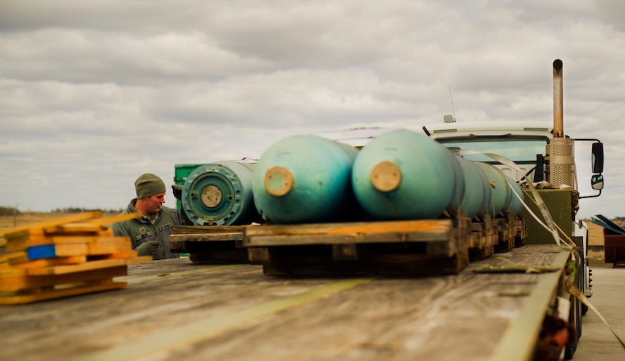 An Airman from the 5th Munitions Squadron unloads weapons during Tundra Thunder at Minot Air Force Base, N.D., May 12, 2014. The exercise is intended to flex the 5th MUN’s conventional munitions generation capabilities to support B-52H Stratofortress operations, either deployed or at home station.  (U.S. Air Force photo/Senior Airman Brittany Y. Auld)