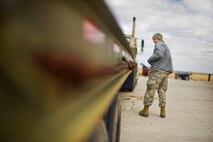 An Airman from the 5th Munitions Squadron unloads weapons during Tundra Thunder at Minot Air Force Base, N.D., May 12, 2014. The exercise is intended to flex the 5th MUN’s conventional munitions generation capabilities to support B-52H Stratofortress operations, either deployed or at home station.  (U.S. Air Force photo/Senior Airman Brittany Y. Auld)