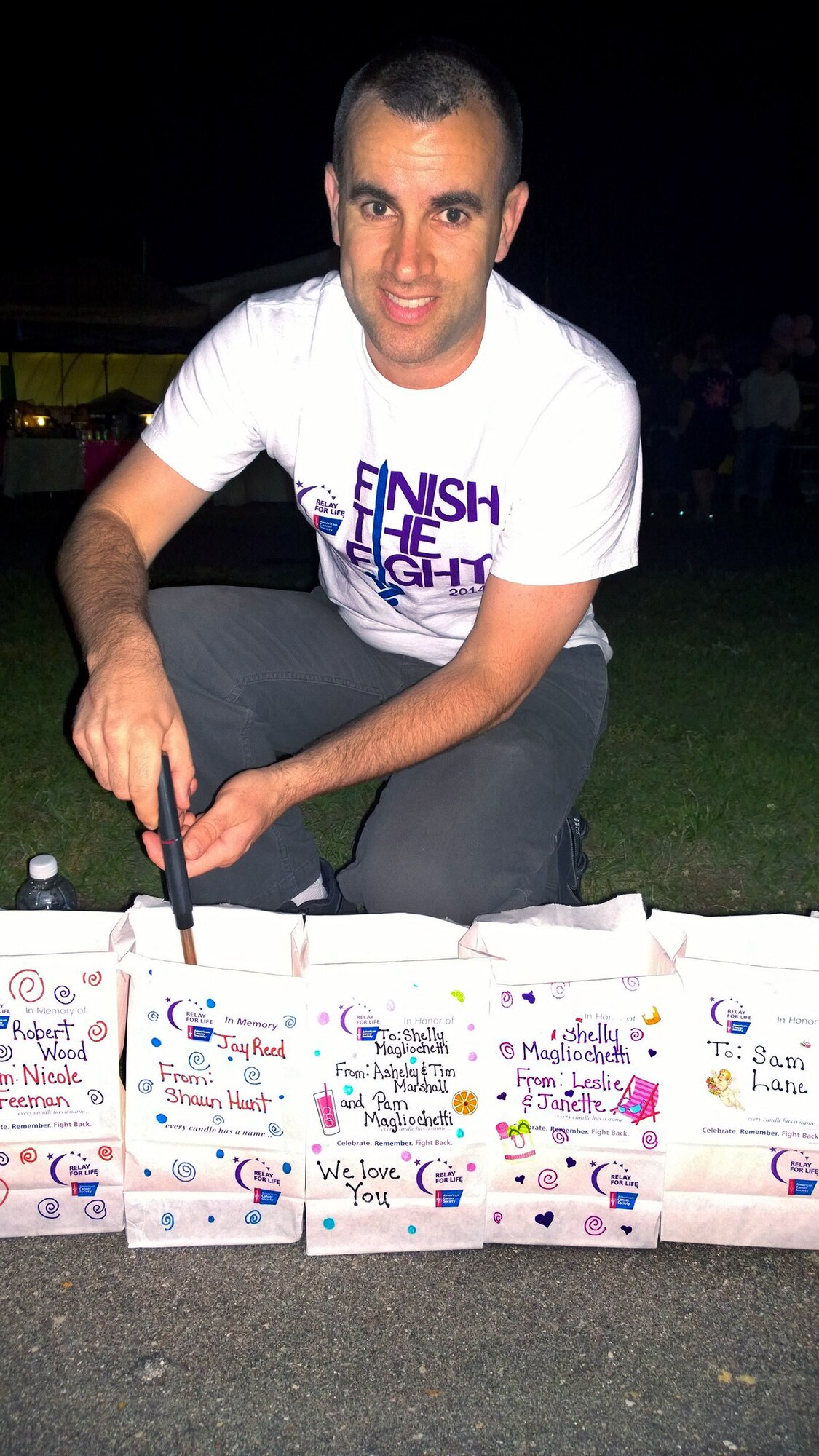 In honor of a family member who survived cancer, Maj. Shaun Hunt, 4th Contracting Squadron commander, lights a luminary during an American Cancer Society Relay for Life event, May 16, 2014, in Goldsboro, North Carolina. Airmen from Seymour Johnson Air Force Base along with community members united to help fight against cancer. The American Cancer Society is a private organization and has no governmental status. (U.S. Air Force photo/Maj. Amber Millerchip)