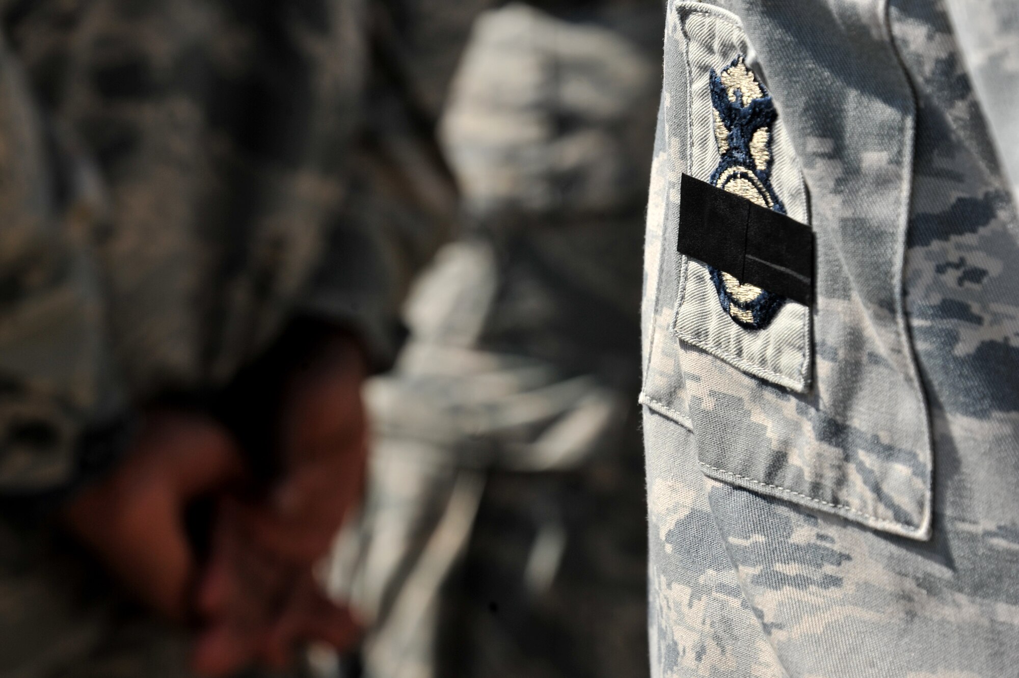 Members of the 42nd Security Forces Squadron wear a black ribbon across their security forces badges, May 16, 2014, during a National Police Week retreat ceremony here. The ribbon signifies SFS members as well as civilian law enforcement, who lost their lives in the line of duty.  Police week is held annually to recognize the men and women who keep this country locally and abroad. (U.S. Air Force photo by Staff Sgt. Natasha Stannard)