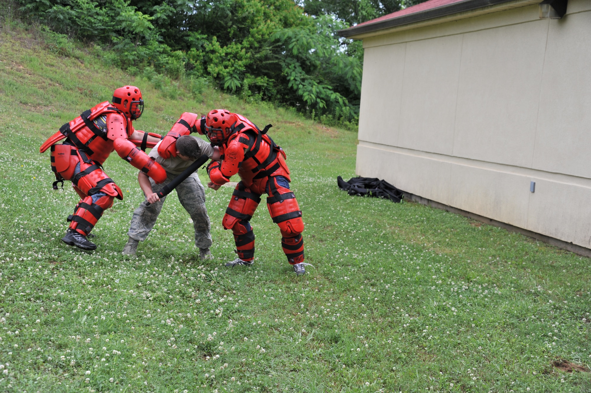Senior Airman Eric Sweat, 42nd Security Forces Squadron vehicle noncommissioned officer, is attacked by two “red men” wearing protective padding as part of the National Police Week obstacle course challenge organized by the 42nd SFS, on Maxwell Air Force Base, May 15, 2014. The challenge was designed to improve teamwork and cohesion and improve morale among different units on base, along with broadening other career fields’ understand of the security forces mission. (U.S. Air Force Photo by Staff Sgt. Gregory Brook)