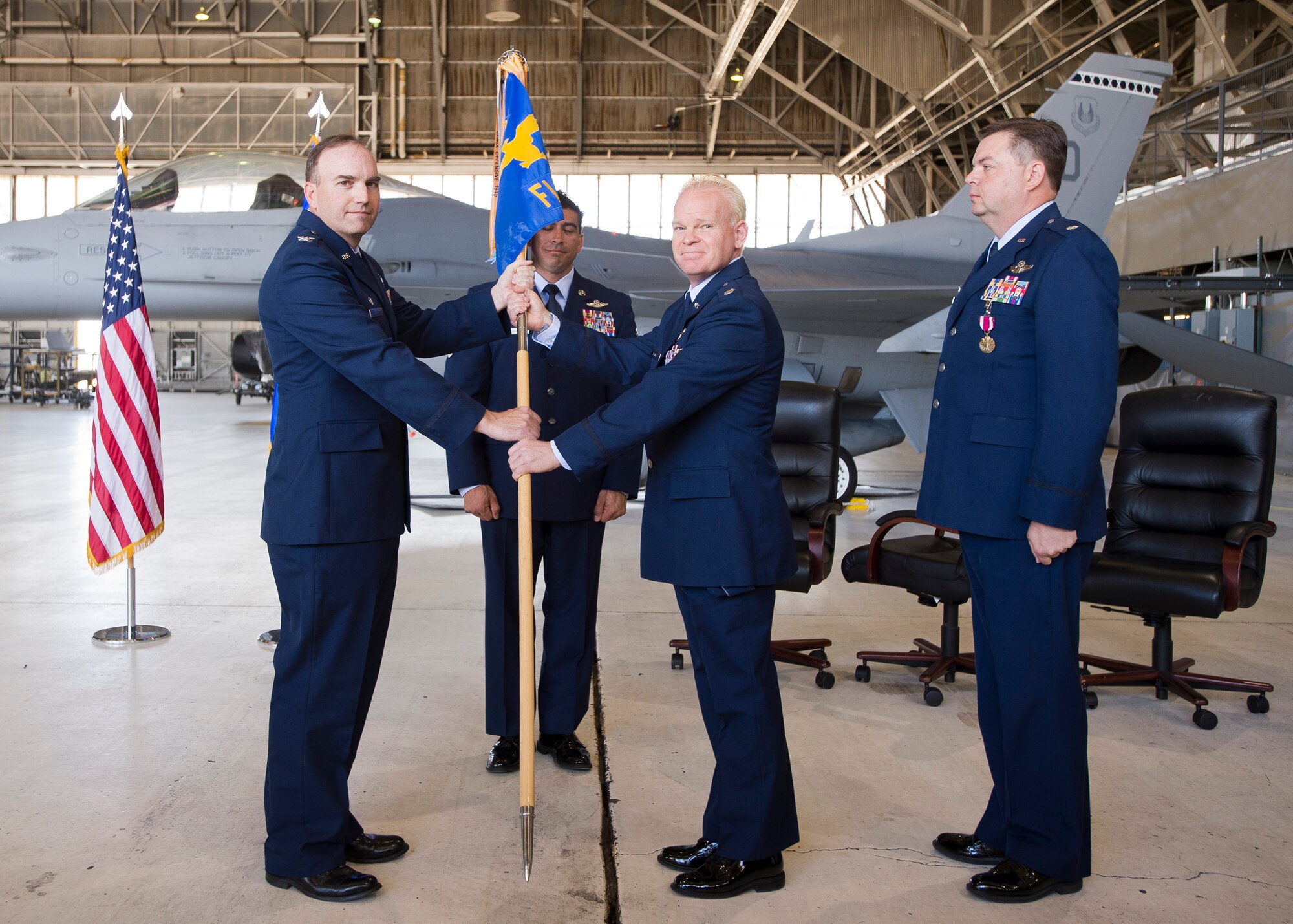 From left: Col. Jerry C. Byars Jr., 413th Flight Test Group, hands Lt. Col. Joshua S. Davies the 370th Flight Test Squadron guidon signifying the squadron's change of command as outgoing commander Lt. Col. Patrick Dulaney looks on. (U.S. Air Force photo by Ethan Wagner)
