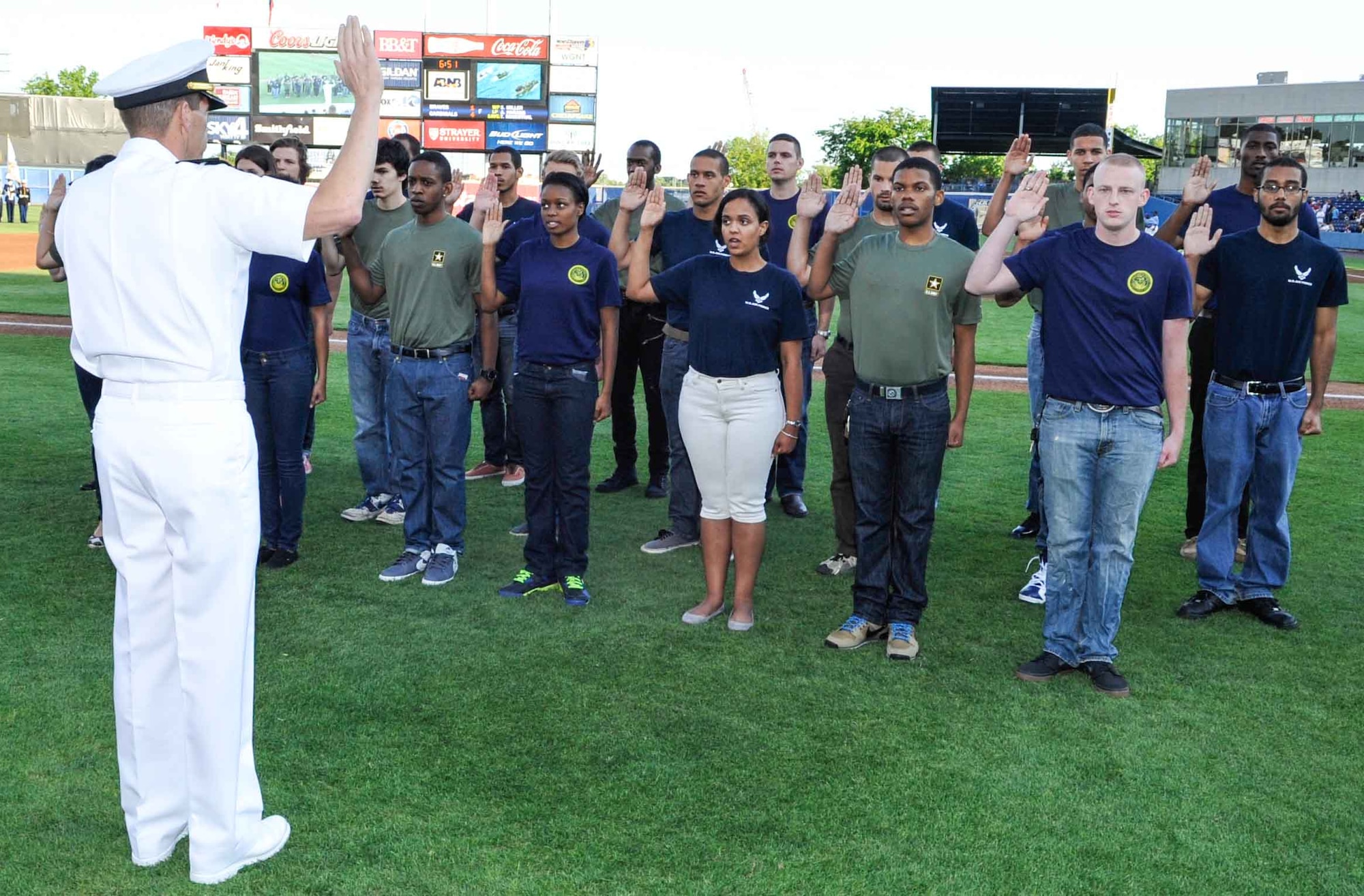 U.S. Navy Rear Adm. Dixon Smith, Navy Region Mid-Atlantic commander, administers the oath of enlistment to 25 Delayed Entry Program participants during the opening ceremony of the Norfolk Tides’ 19th Annual Armed Forces Night at Harbor Park Stadium in Norfolk Va., May 17, 2014. The event honored Service members from all branches of the Armed Forces within the local community. (U.S. Air Force photo by Staff Sgt. Wesley Farnsworth/Released)
