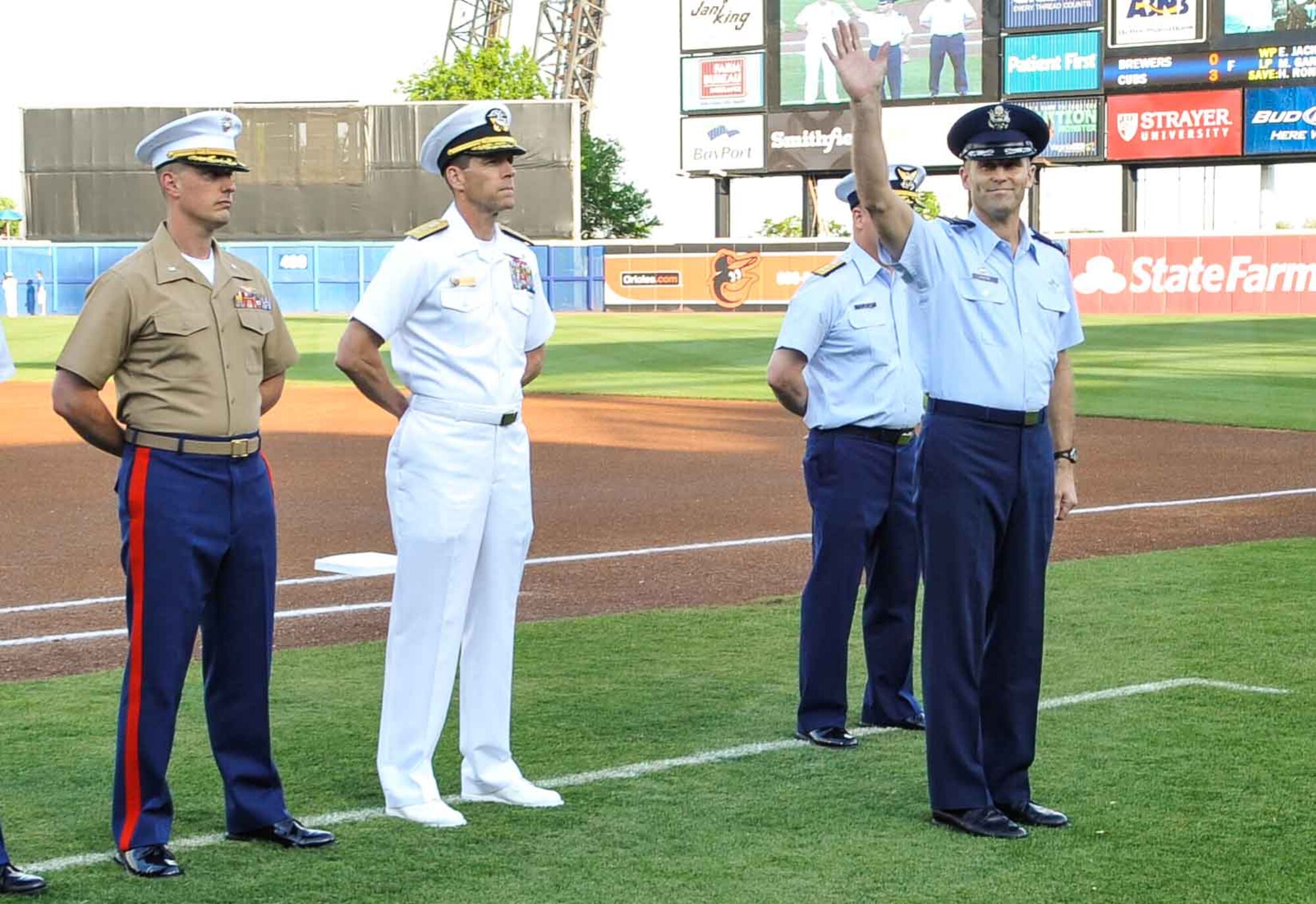 U.S. Air Force Col. Kevin Huyck, 1st Fighter Wing commander, waves to the crowd during the opening ceremony of the Norfolk Tides’ 19th Annual Armed Forces Night at Harbor Park Stadium in Norfolk, Va., May 17, 2014. The event included a presentation of the colors by the U.S. Joint Service Color Guard and first pitches by Service members from each branch of the Armed Forces. (U.S. Air Force photo by Staff Sgt. Wesley Farnsworth/Released)